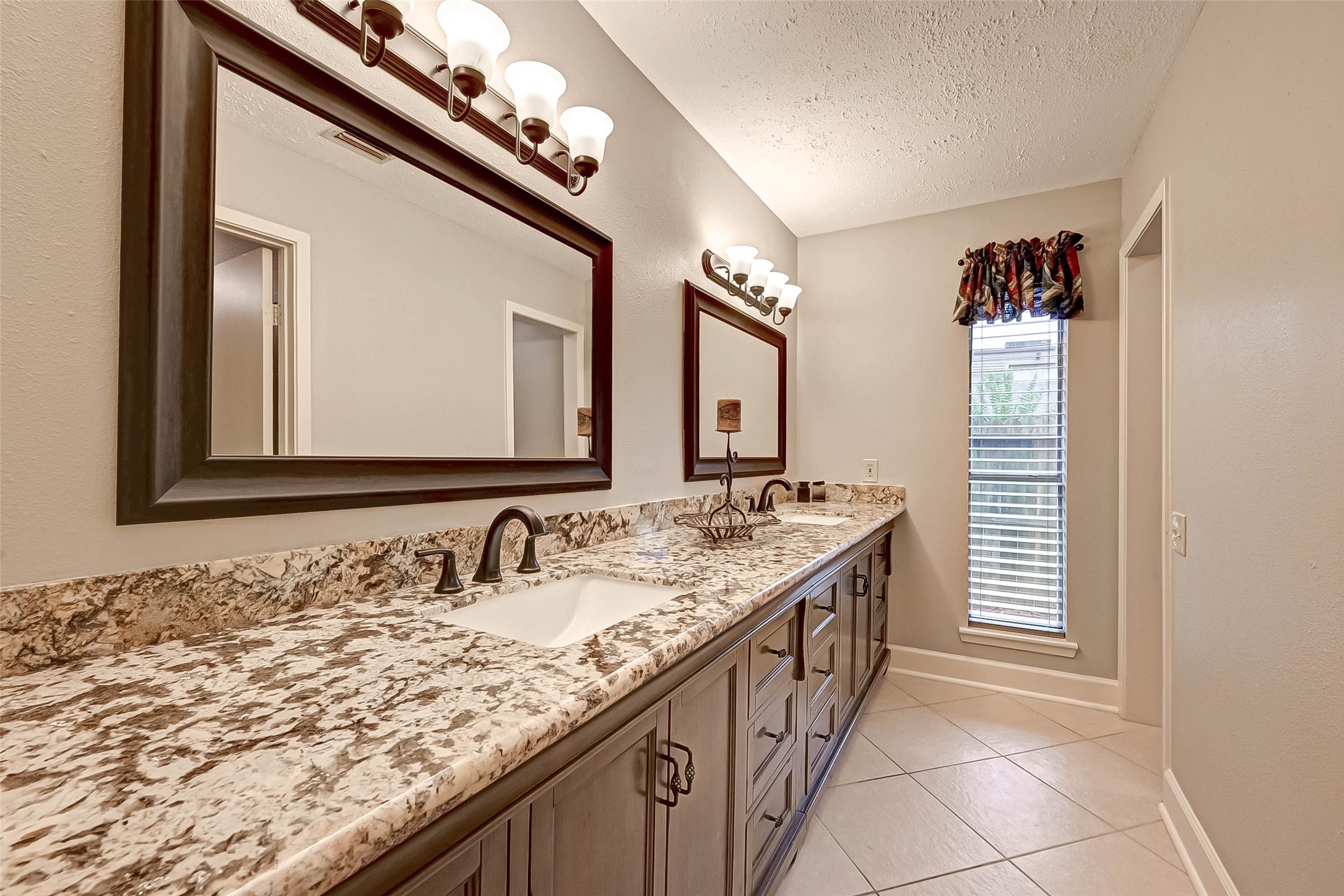 Primary bathroom with double sinks and granite.