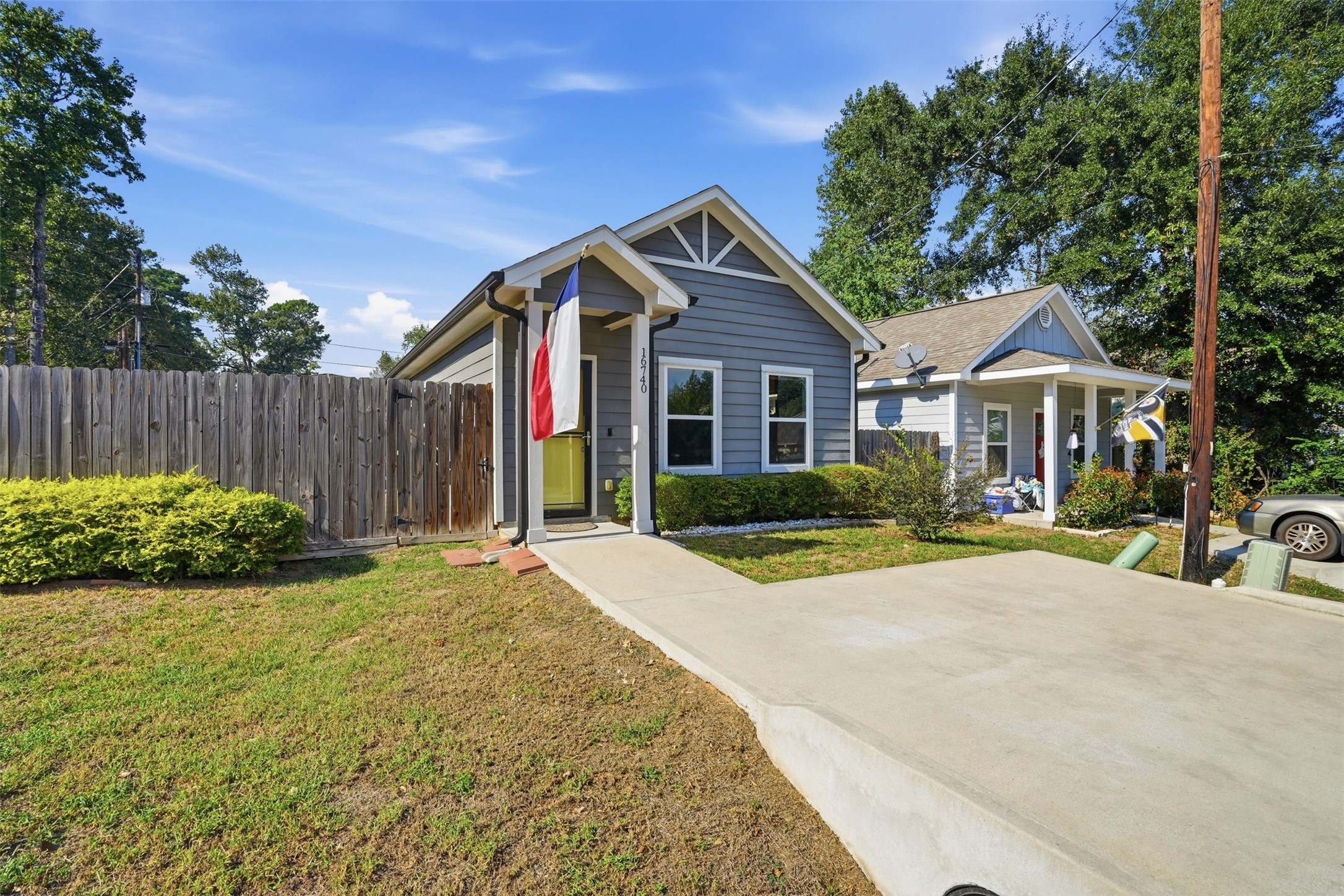 Home with a modern gray exterior, inviting front porch, and nice landscaping, nestled in a quiet neighborhood.