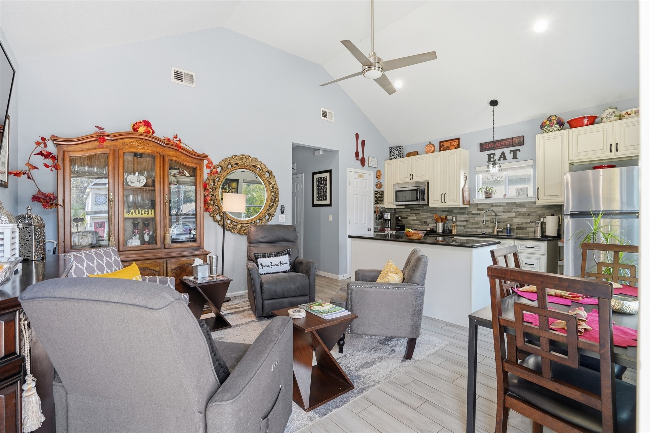Open-concept living area featuring vaulted ceilings, modern kitchen with stainless steel appliances, and cozy seating perfect for relaxation and entertaining.