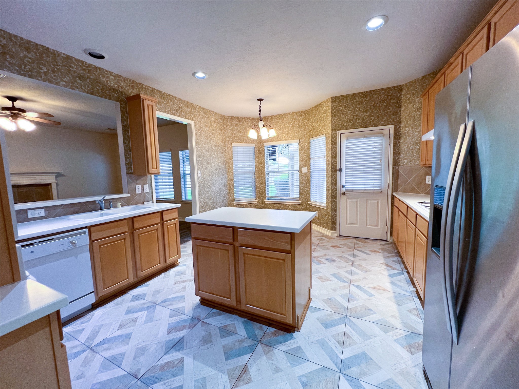 Step into a spacious kitchen featuring sleek stainless steel appliances, elegant tile flooring, and abundant natural lightperfect for culinary adventures and family gatherings.