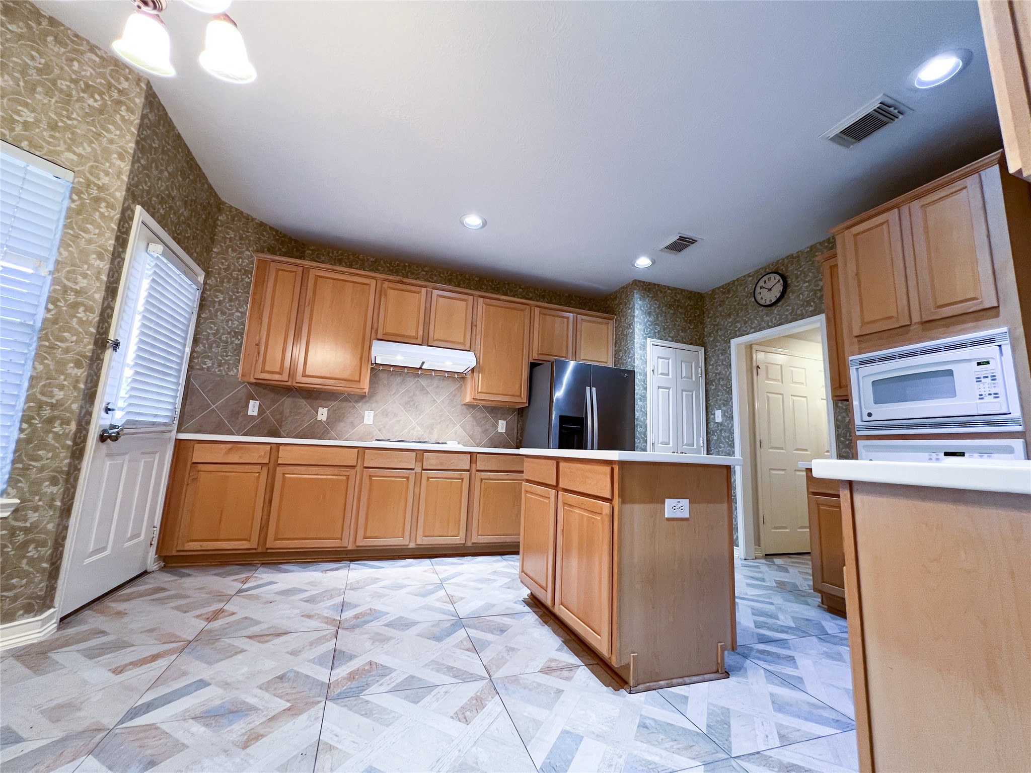 Spacious and inviting, this kitchen boasts warm wooden cabinetry, sleek appliances, and a stylish tile floor, perfect for both cooking and entertaining. Spacious and inviting, this kitchen boasts warm wooden cabinetry, sleek appliances, and a stylish tile floor, perfect for both cooking and entertaining.
