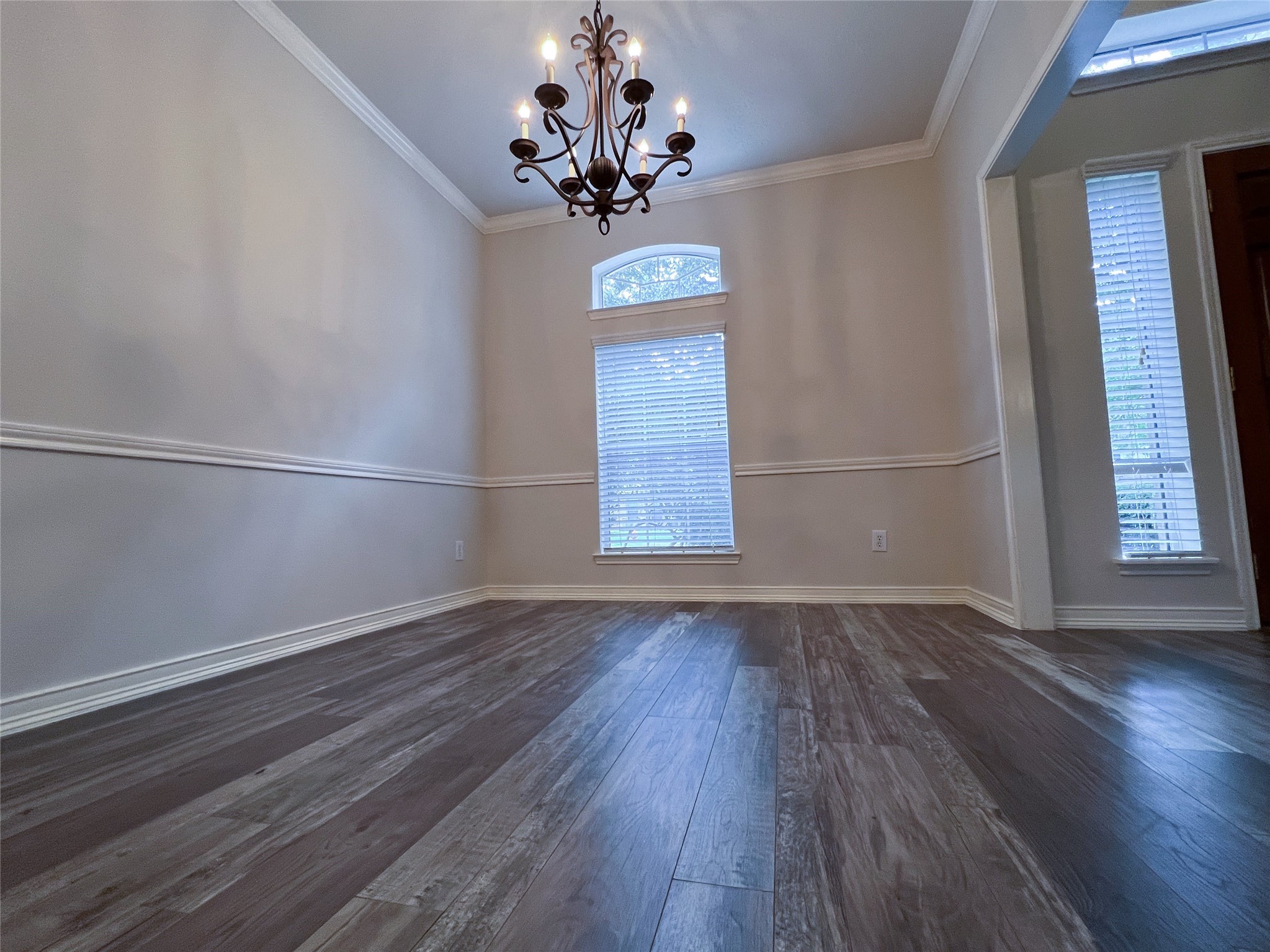 Experience elegant dining in this inviting room, featuring rich floors, a stylish chandelier, and abundant natural light through large windows. Experience elegant dining in this inviting room, featuring rich floors, a stylish chandelier, and abundant natural light through large windows.