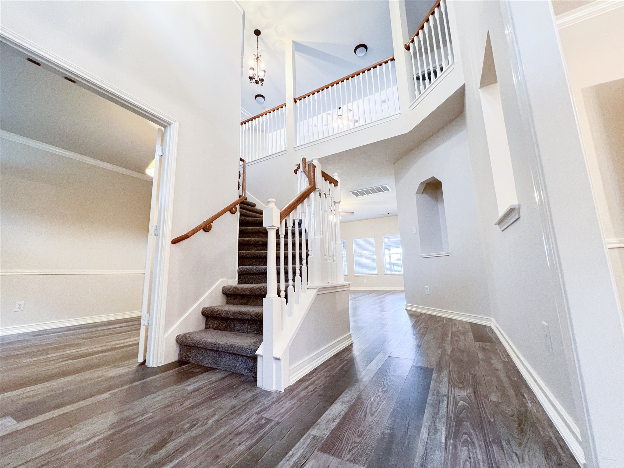Step into elegance with this grand foyer, featuring soaring ceilings, a stylish staircase, and abundant natural light, setting a welcoming tone for the entire home. Step into elegance with this grand foyer, featuring soaring ceilings, a stylish staircase, and abundant natural light, setting a welcoming tone for the entire home.