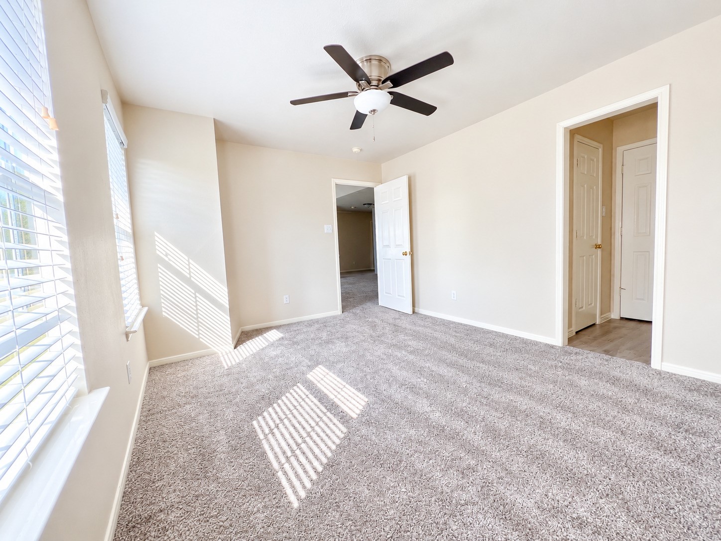 Sunlit and spacious, Bedroom 3 on the second floor offers a cozy retreat with plush carpeting and a modern ceiling fan, perfect for relaxation.