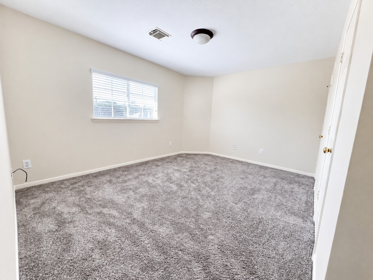 Bedroom 5 on the second floor offers a spacious retreat with plush carpeting and abundant natural light, perfect for relaxation.
