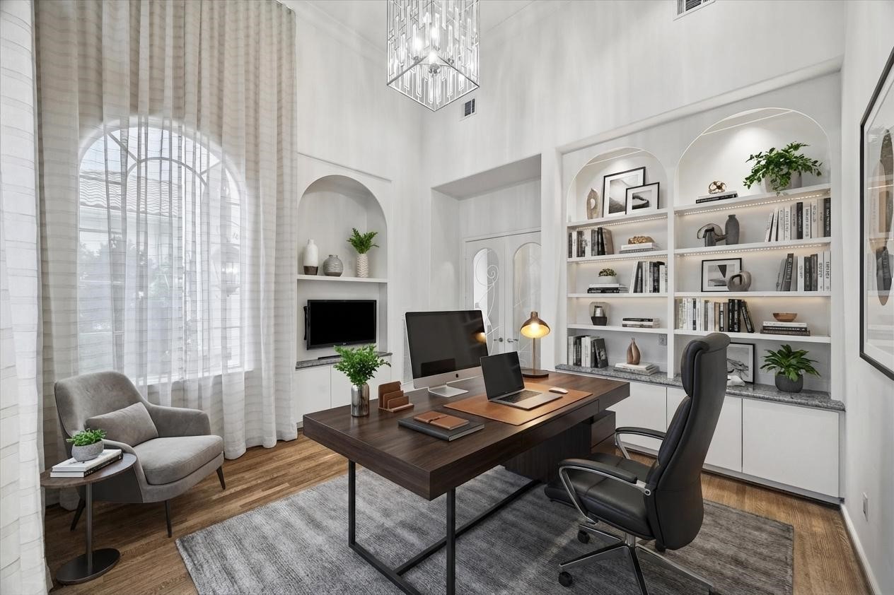 VIRTUALLY STAGED - spacious and private home office/library - accented with a high ceiling and dramatic contemporary chandelier - built-in shelving and cabinetry for your cherished books and accessories, not shown is a pair of mirror-backed lighted shelves for display, flanking an arched window