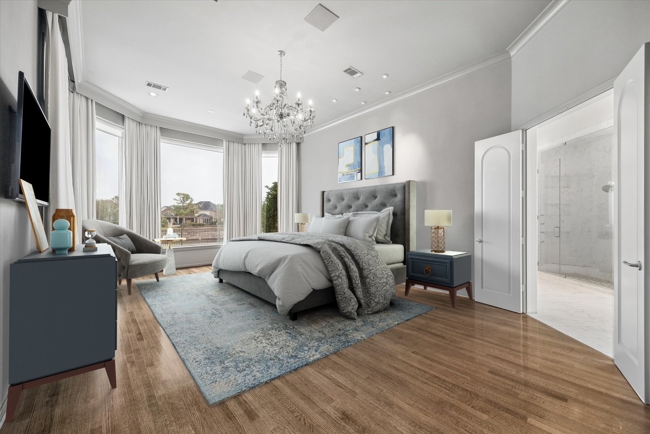 VIRTUALLY STAGED - elegant primary bedroom in a serene color palette - beautiful chandelier and recessed lighting, hardwood flooring