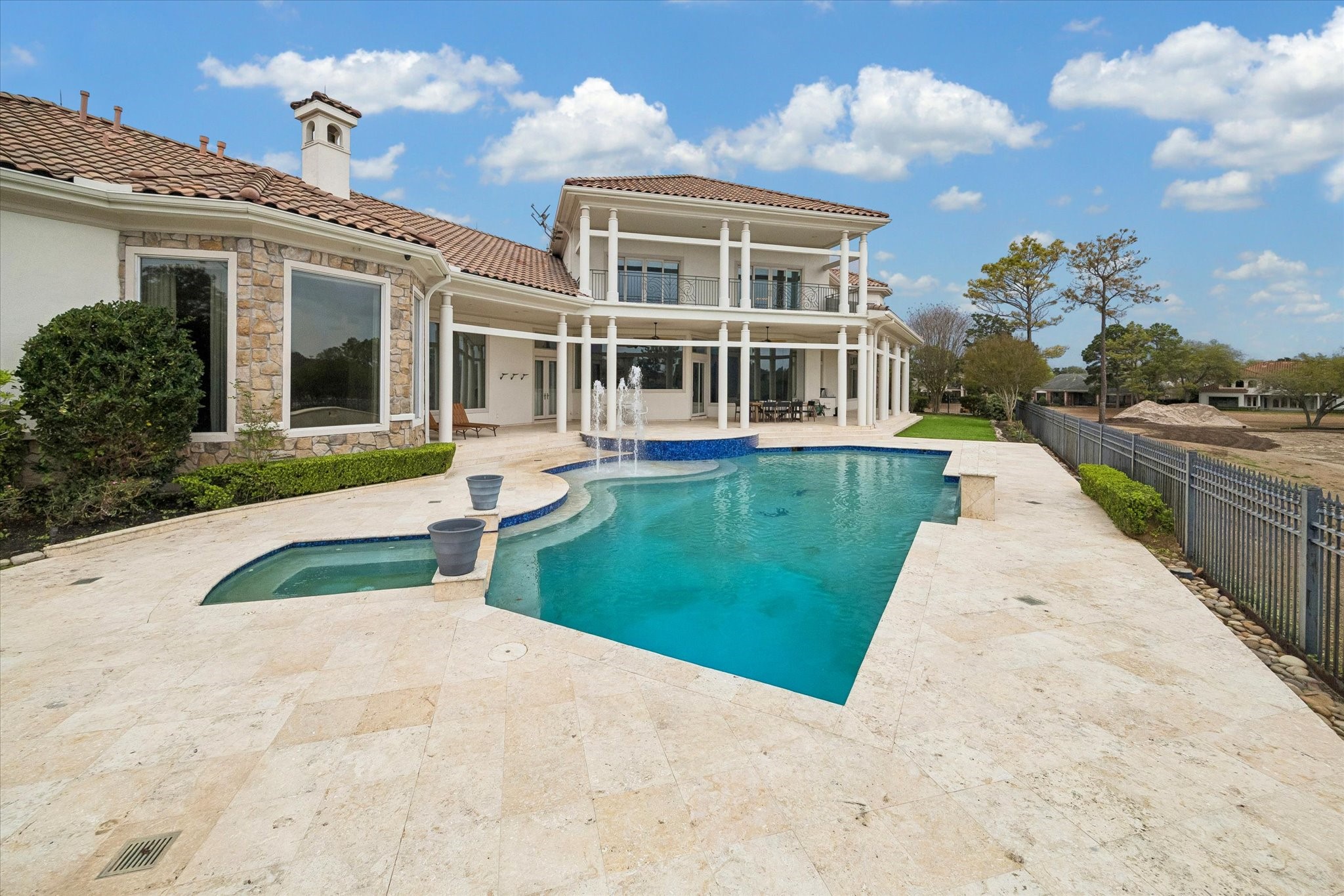VIEW OF EXTENSIVE TERRACES SURROUNDING THE HOME AND POOL/SPA - enjoyable outdoor living on open and covered terraces, note the balcony on the 2nd level with beautiful views from two of the ensuite secondary bedrooms upstairs