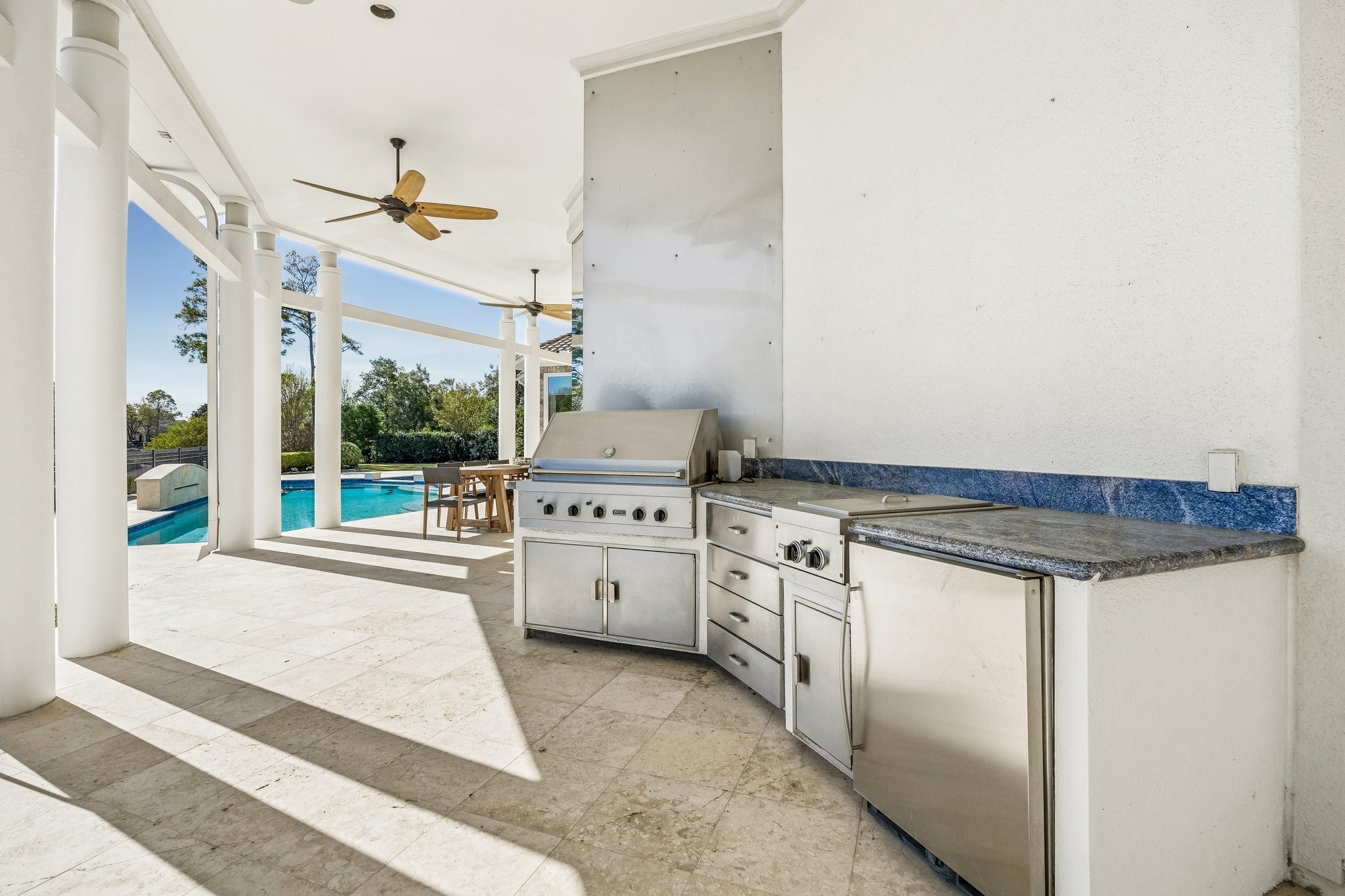 OUTDOOR/SUMMER KITCHEN CONVENIENTLY LOCATED BETWEEN THE GAMEROOM AND ALFRESCO DINING AREAS - Viking outdoor grill and double side burners, built-in mini refrigerator - granite countertops for prep space, storage cabinets plus built-in drawers for utensils and serving pieces