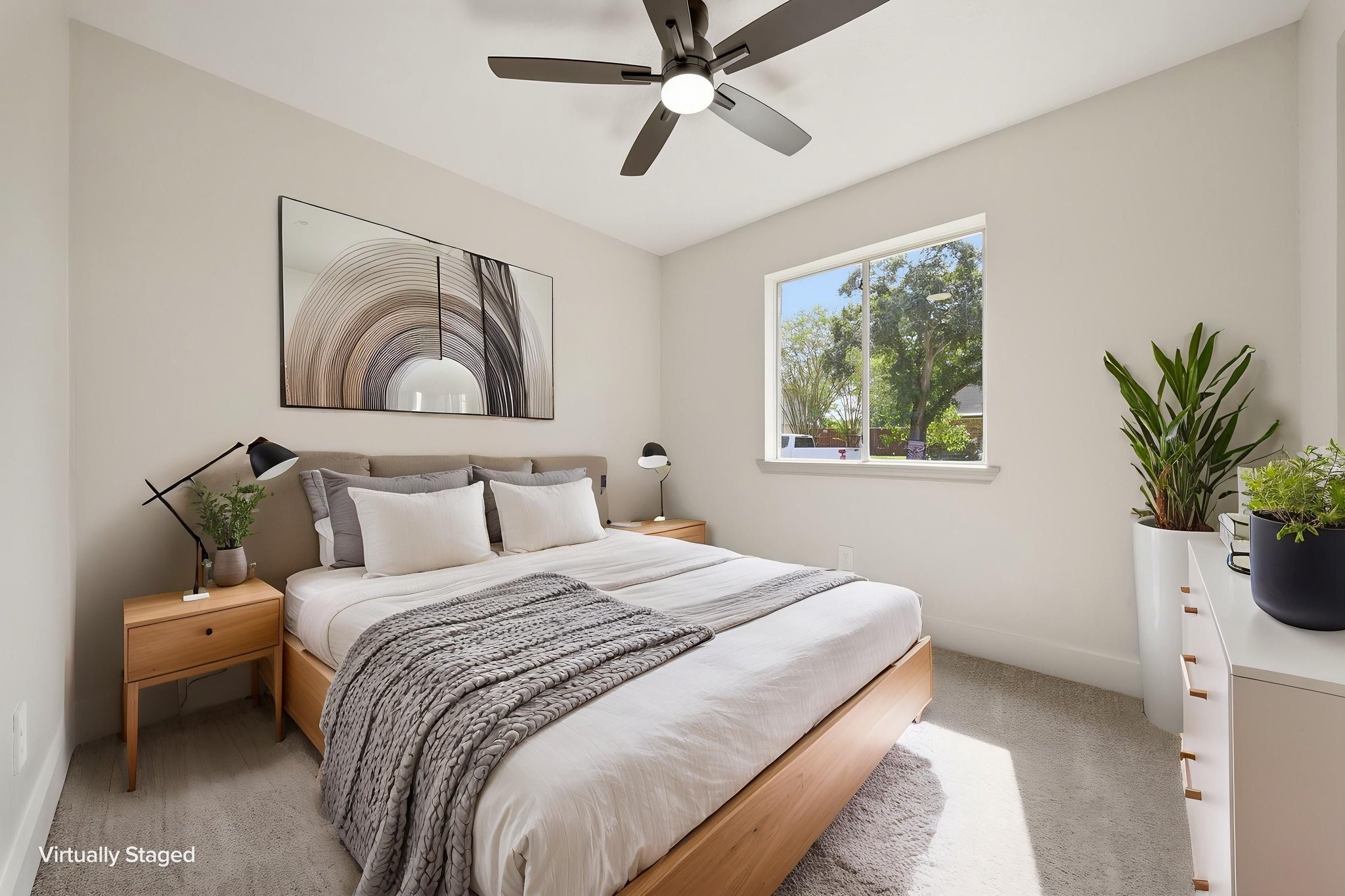 Bright and airy bedroom with modern cozy bed, and a large window offering natural light and scenic views.