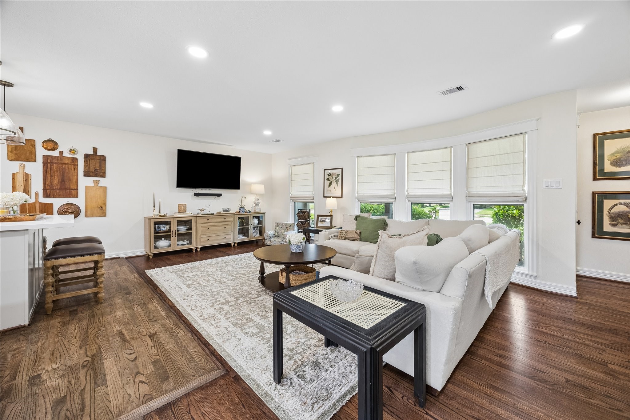 Bright and inviting living area. Recessed LED can lights, hardwood floors, all bathed in natural light from multiple windows.