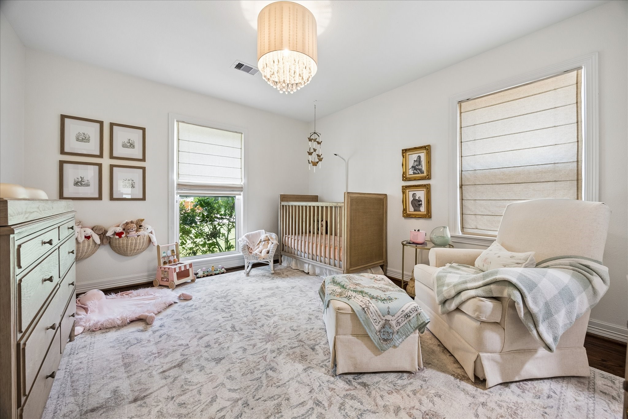 Bedroom 3 with soft neutral tones, Natural light fills the room through large windows with elegant roman shades, creating a serene and inviting atmosphere.