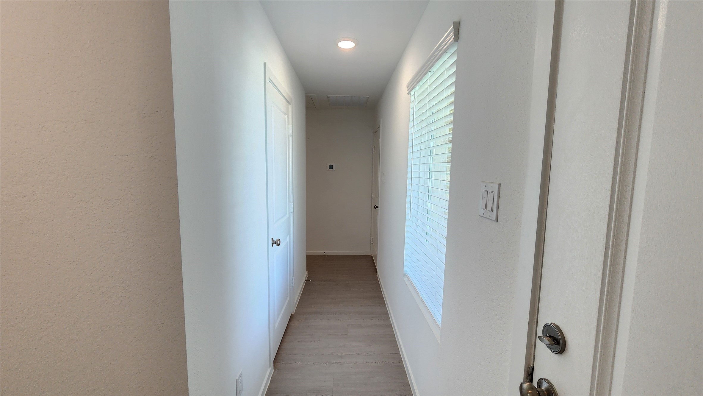 Hall to laundry room leading to 2 additonal bedrooms and hallway bathroom