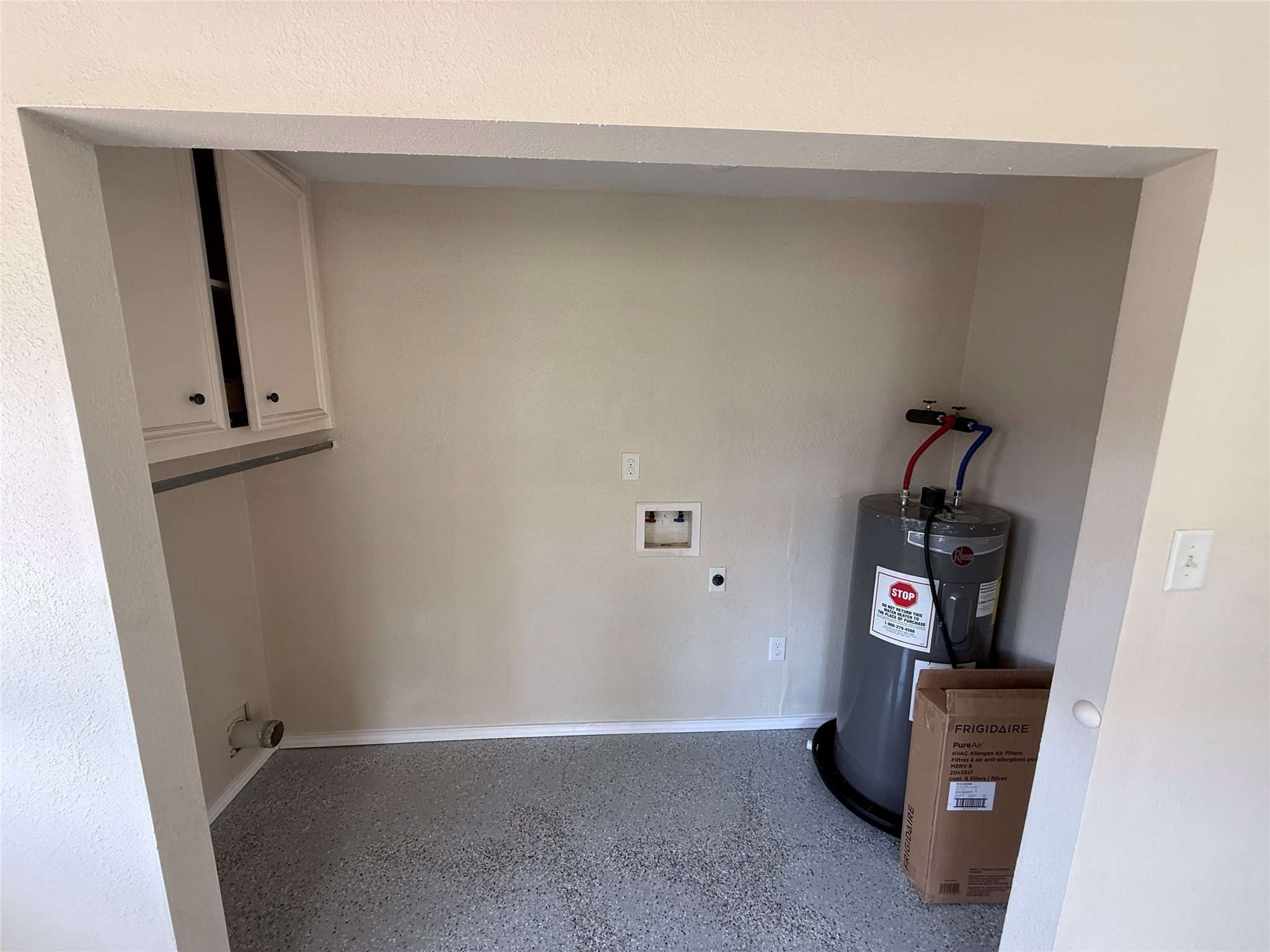 Utility alcove with laundry connections and a water heater.