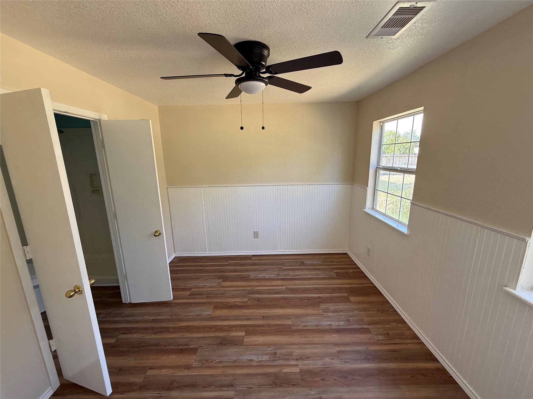 Additional room view showing two-tone walls and access to the adjoining space.