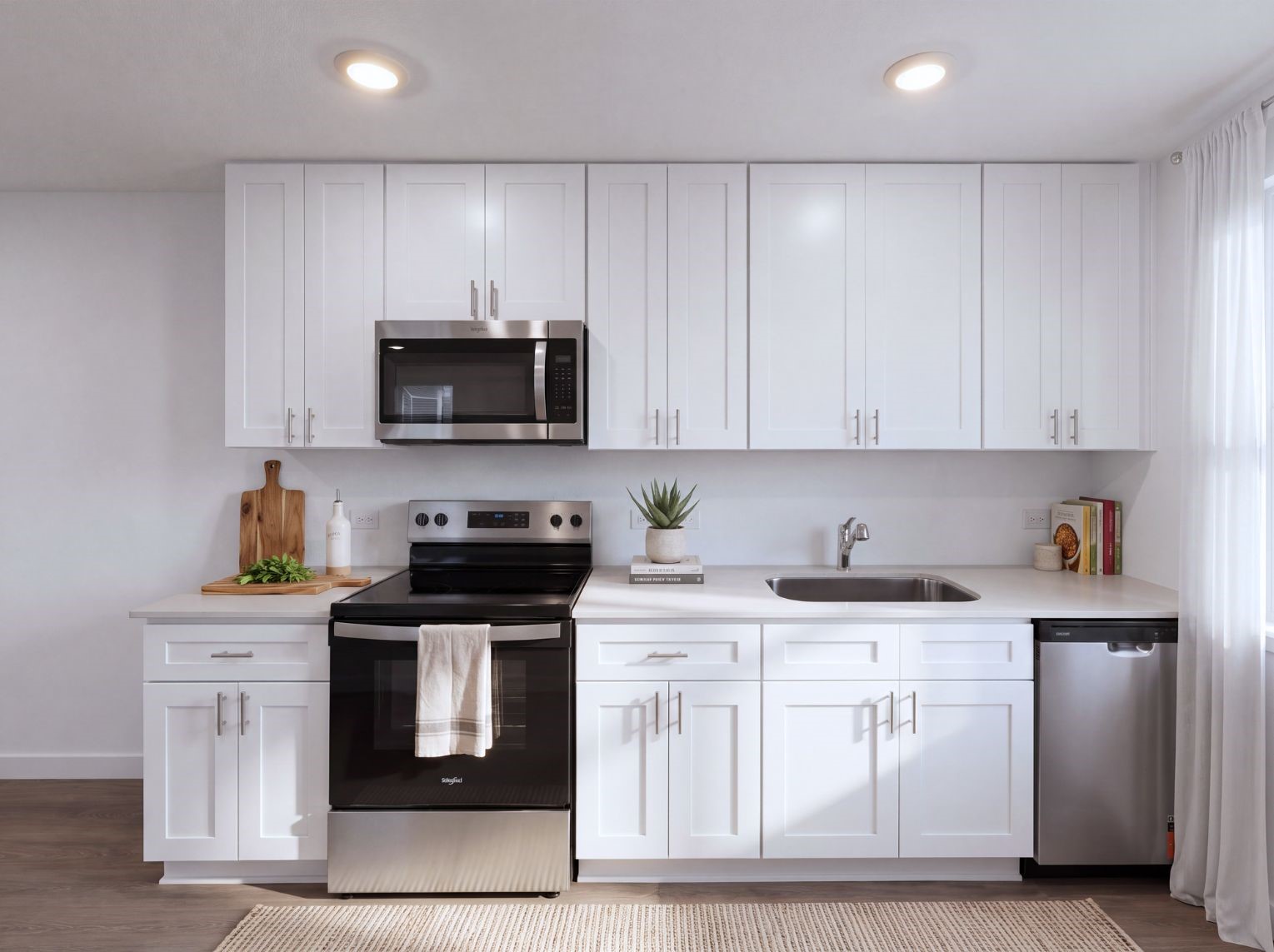 Kitchen with white shaker cabinetry, light stone counters, a stainless steel range, microwave, and dishwasher, plus a single-basin sink. Recessed lighting keeps the space bright.
This photo has been digitally staged to illustrate the possibilities of the home's aesthetic and potential design. Some furnishings and dcor shown are for visual inspiration.