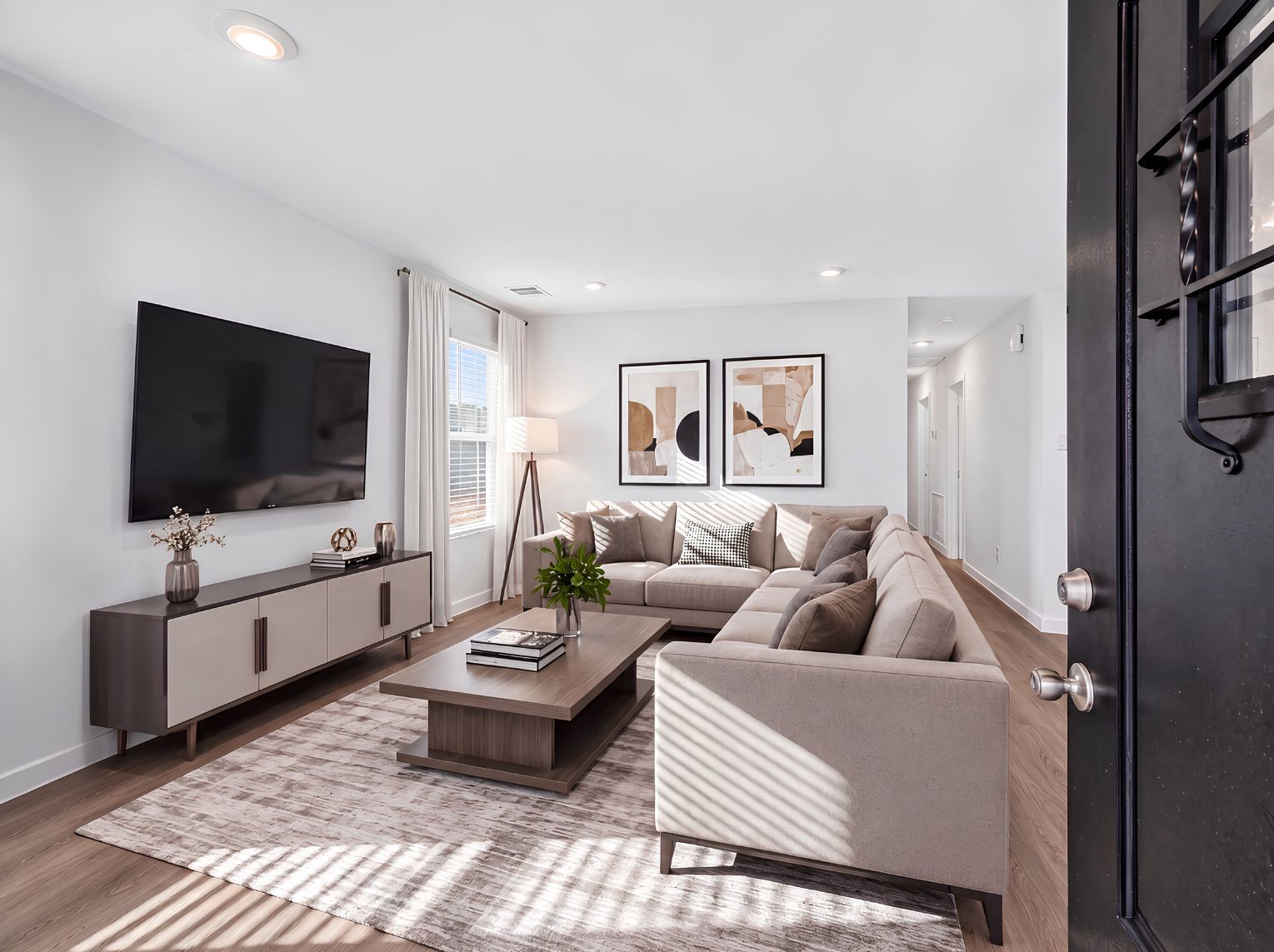 Open living room with wood-look flooring, recessed lighting, and a large window for natural light. Flows directly to the entry and hallway for an easy, connected layout.
This photo has been digitally staged to illustrate the possibilities of the home's aesthetic and potential design. Some furnishings and dcor shown are for visual inspiration.