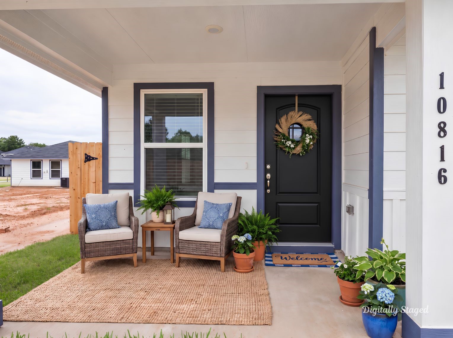 Covered front porch with a wood-tone front door, navy trim accents, and room to sit and relax. A welcoming spot at the home's entry.
This photo has been digitally staged to illustrate the possibilities of the home's aesthetic and potential design. Some furnishings and dcor shown are for visual inspiration.