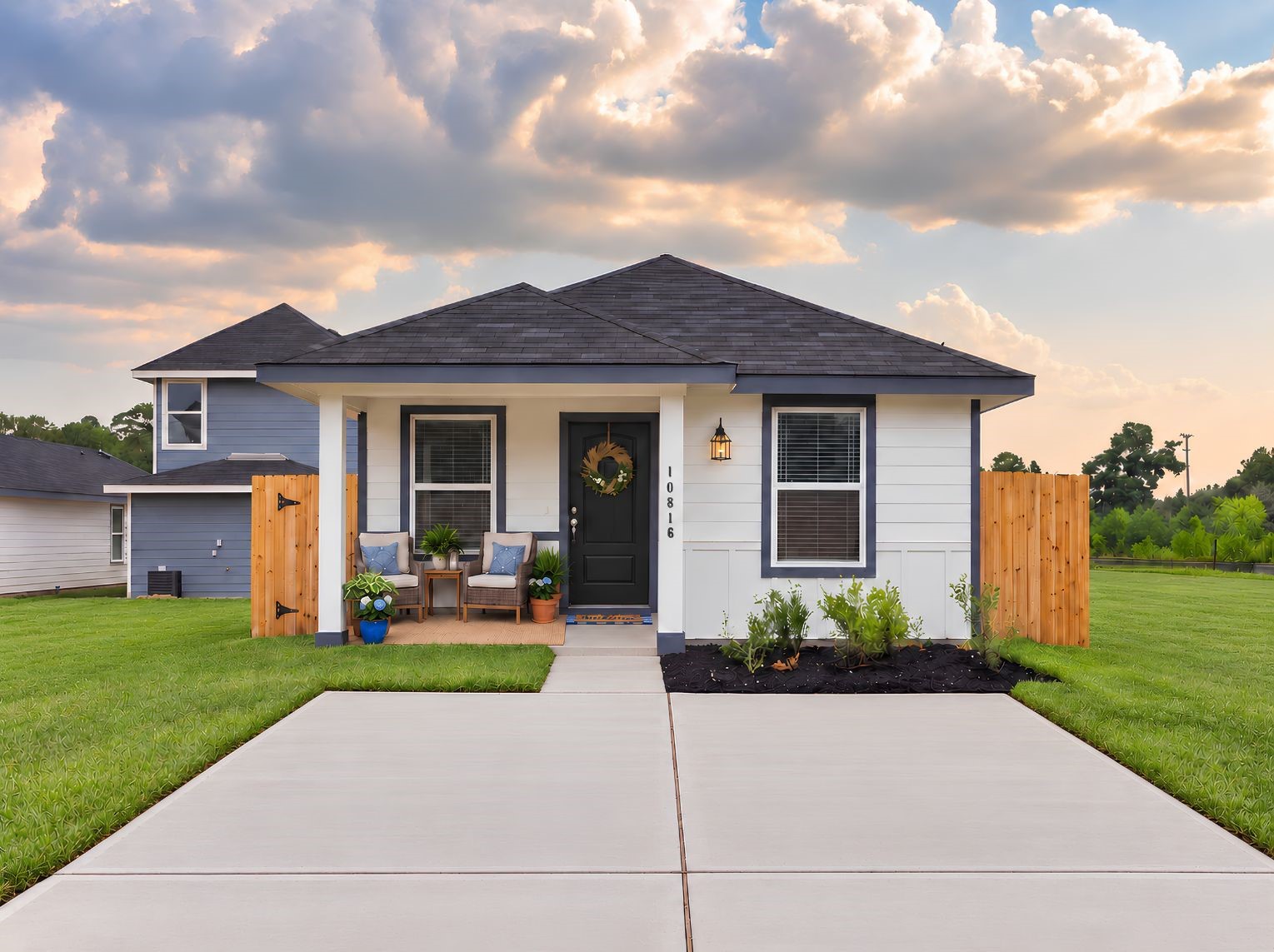 Single-story home with a covered front porch, board-and-batten and lap siding, and clean navy trim. A concrete walkway and driveway lead up to the covered entry.
This photo has been digitally staged to illustrate the possibilities of the home's aesthetic and potential design. Some furnishings and dcor shown are for visual inspiration.