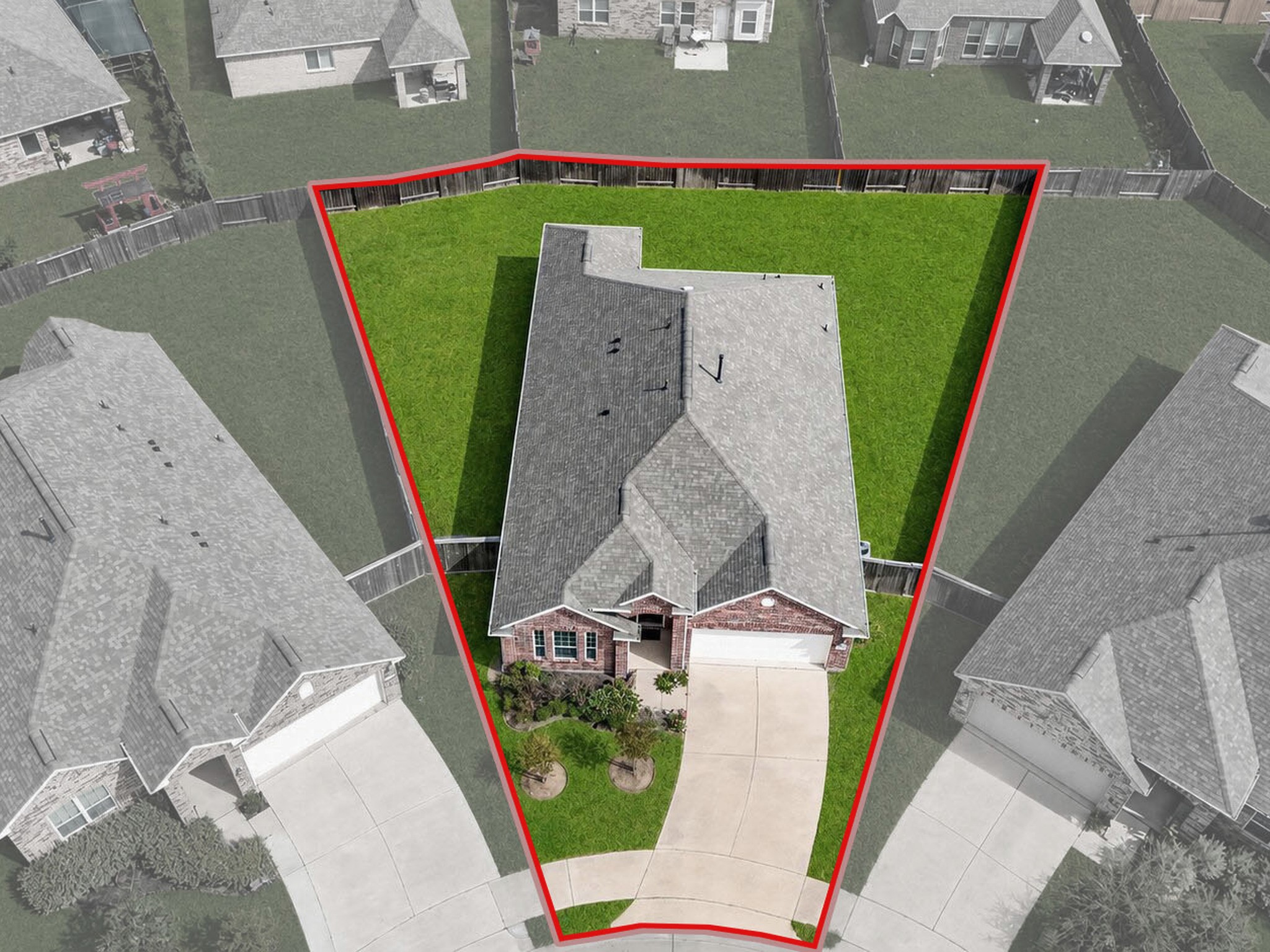 Front aerial view highlights the homes placement on the lot, driveway, and front lawn. Highlighted boundaries are approximate and for illustration only.