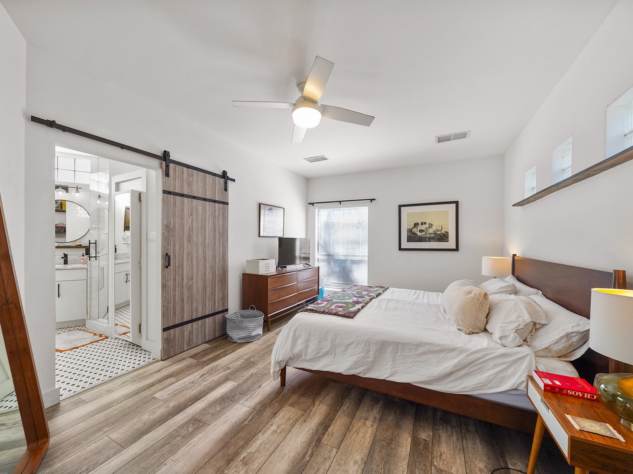 Discover a spacious primary suite awash in natural light, offering a serene retreat with elegant design touches.