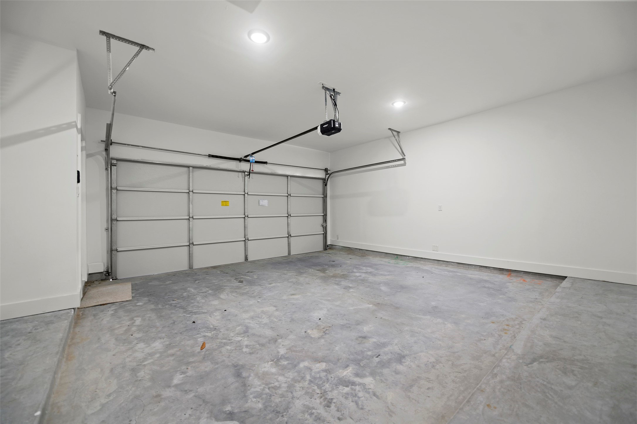 This is a spacious, clean garage with concrete floor and WiFi Automatic door opener, offering ample room for parking and storage.
