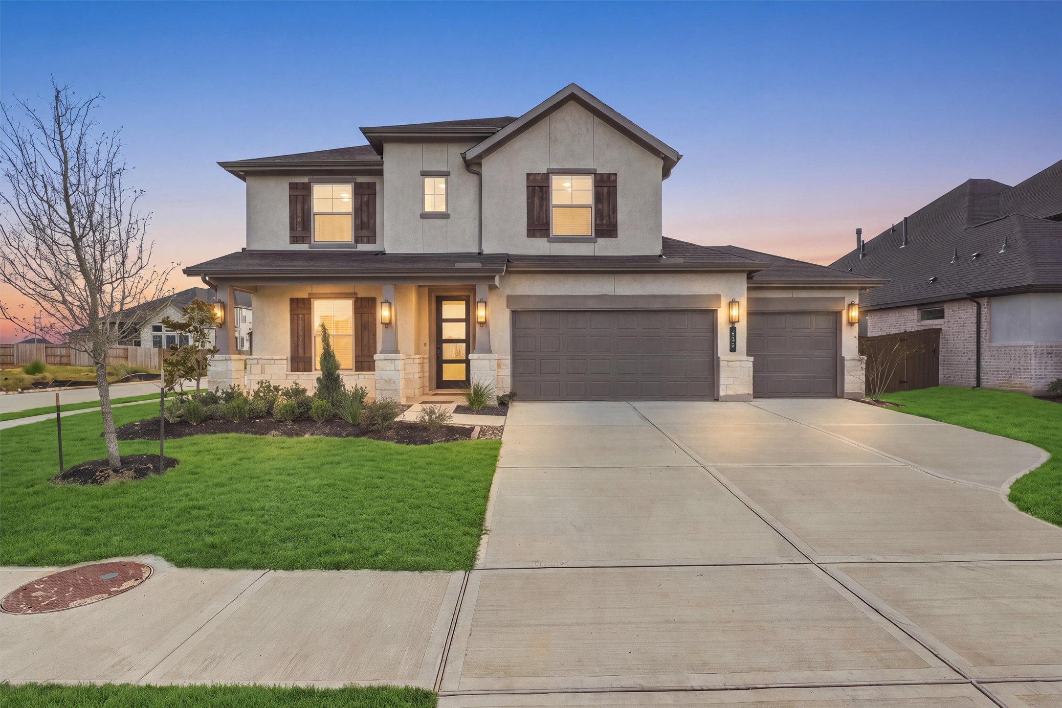 Welcome Home: Stone accents, stucco, and cedar-tone shutters create striking curb appeal, and the lantern sconces glow across a covered front porch. Welcome Home: Stone accents, stucco, and cedar-tone shutters create striking curb appeal, and the lantern sconces glow across a covered front porch.