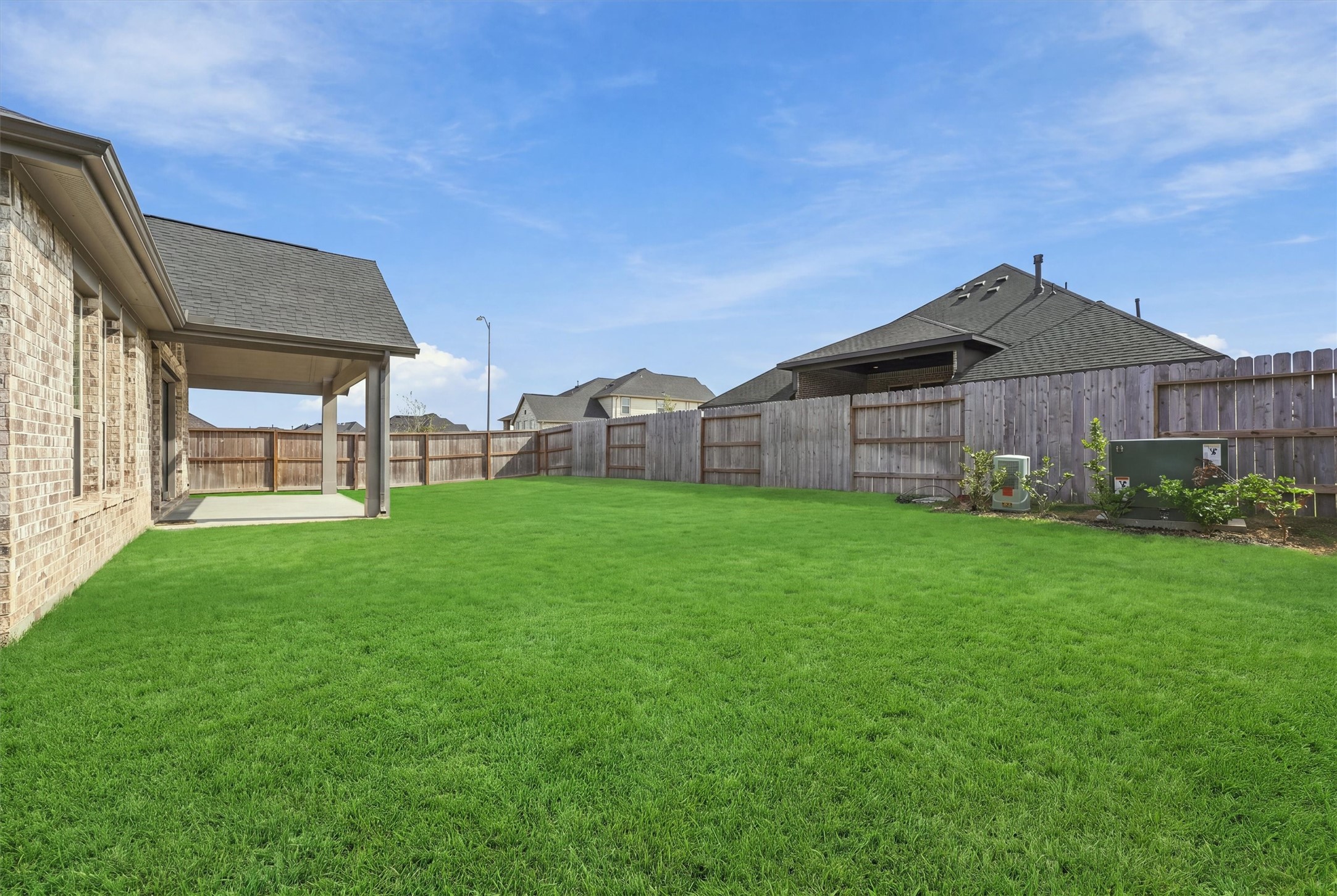 A wide, level lawn behind a full privacy fence, with plenty of room to entertain.