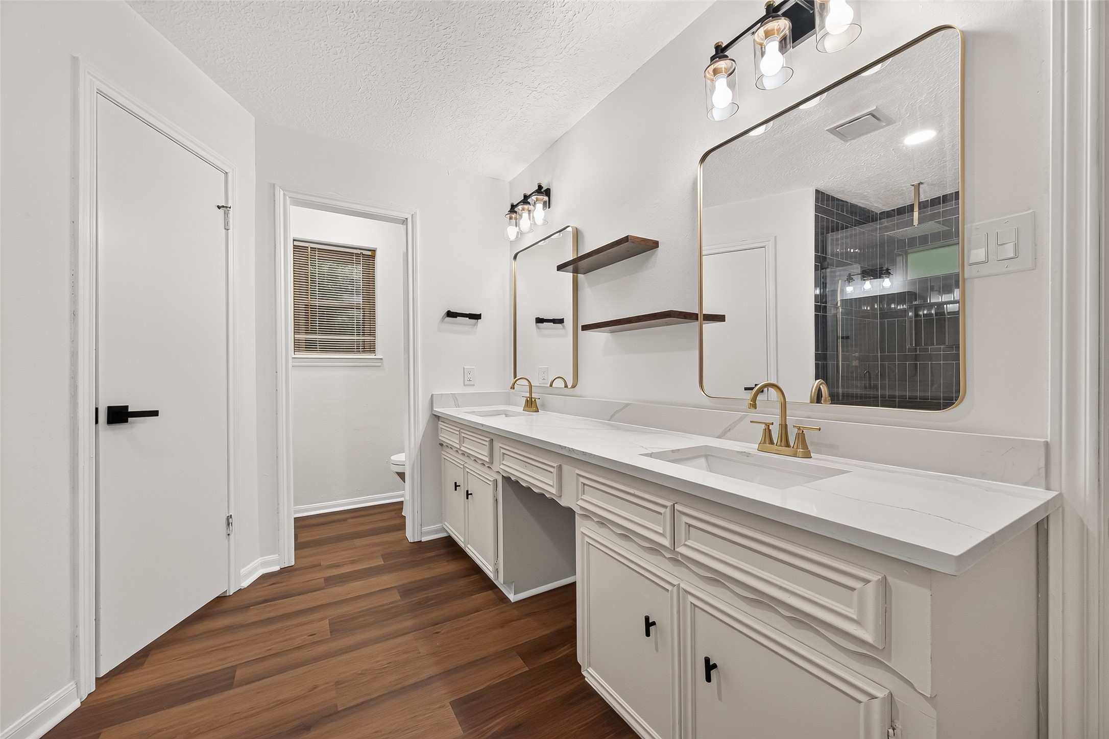 Beautiful dual-sink vanity with
elegant gold accents and modern
floating shelves