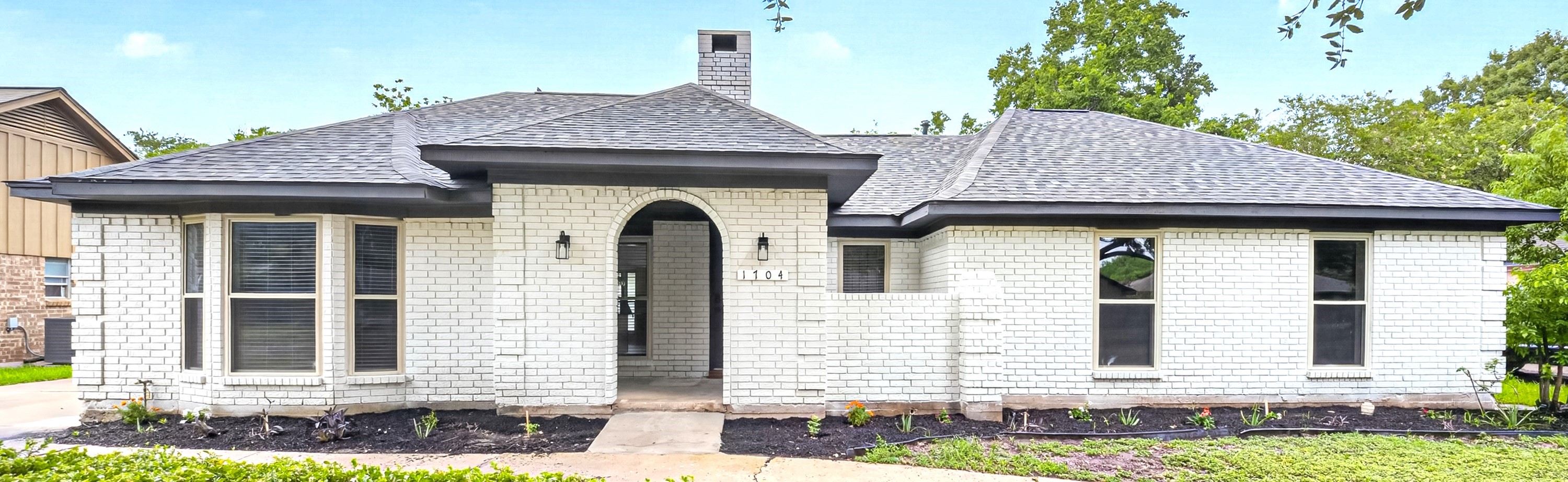 Full brick exterior with a private driveway and a spacious outdoor patio
