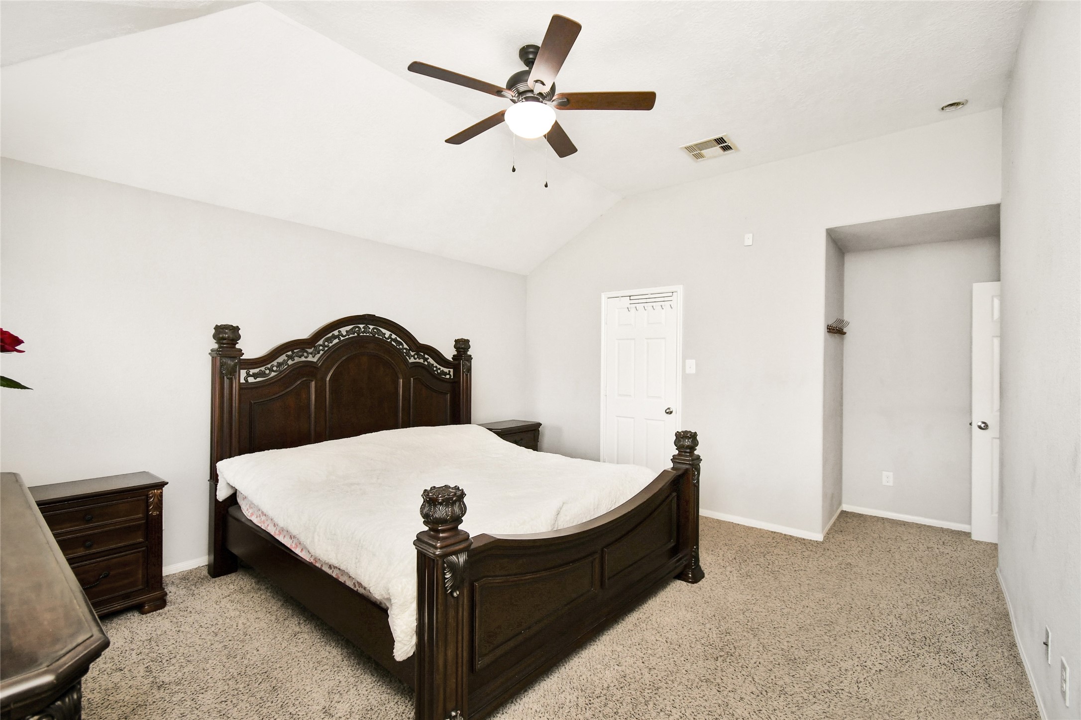 Generously sized primary suite with soft carpet flooring and a walk-in closet nook.