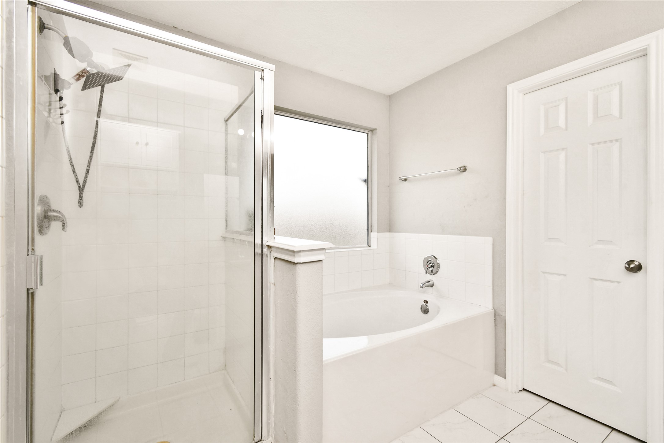 Relaxing en suite featuring a separate glass shower and a deep soaking tub with tiled surround.