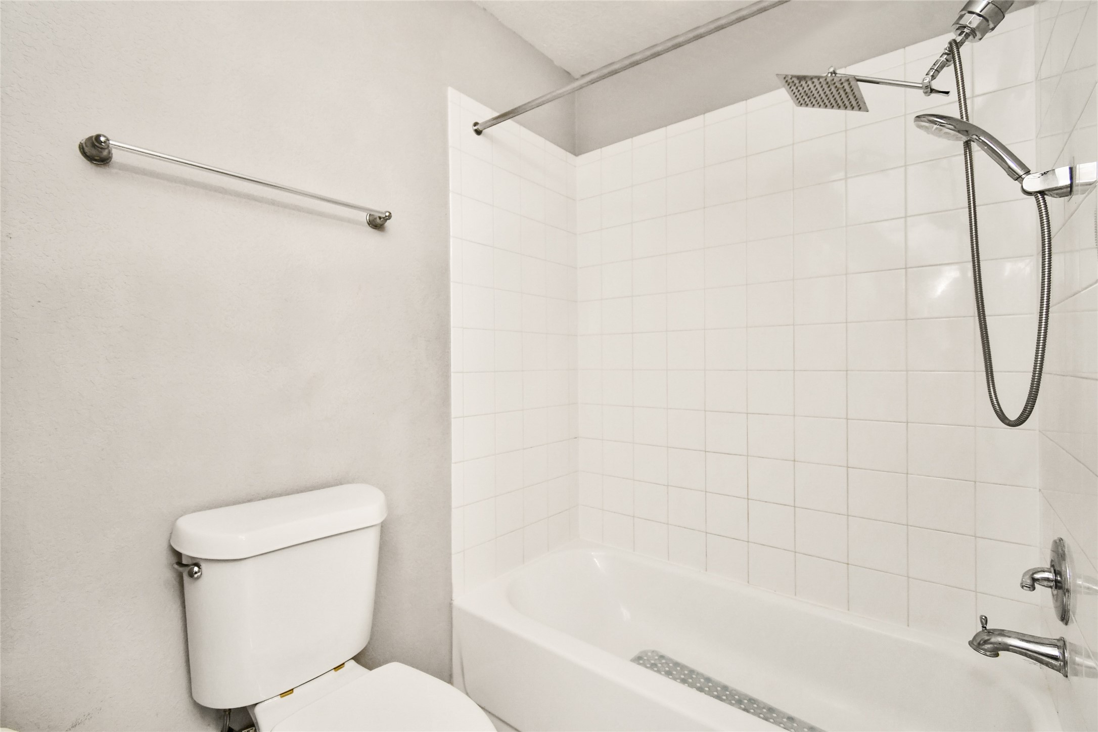 Clean tub and shower combo with tile surround and a convenient rain shower head.