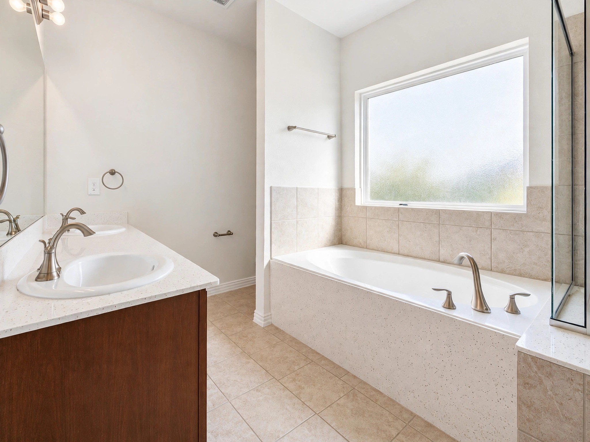 Another view of the bathroom showcases the vanity, soaking tub, and natural light. Another view of the bathroom showcases the vanity, soaking tub, and natural light.