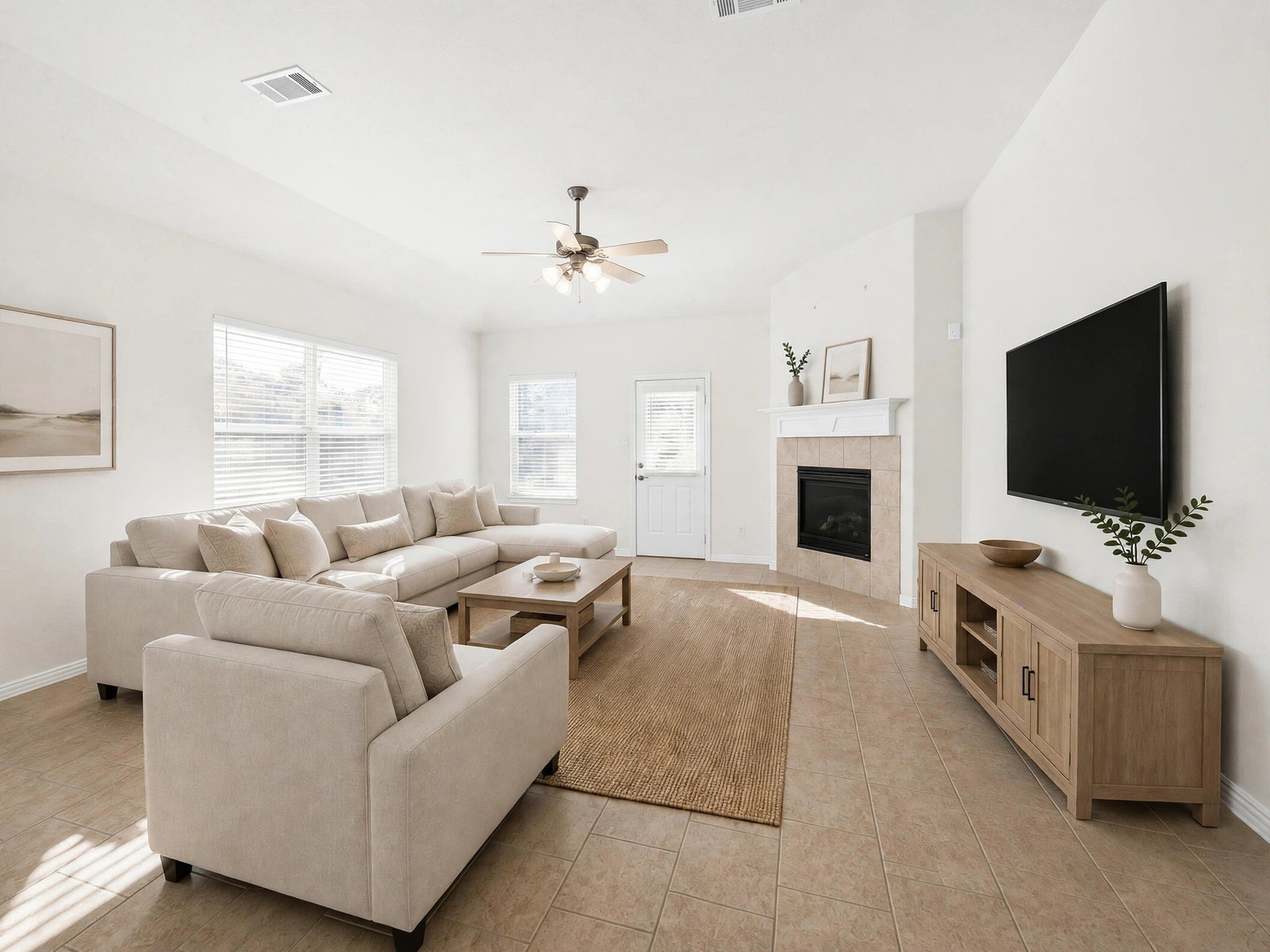 Furnished living room view highlights the fireplace, natural light, and space for gathering and relaxing. (Virtually staged)
