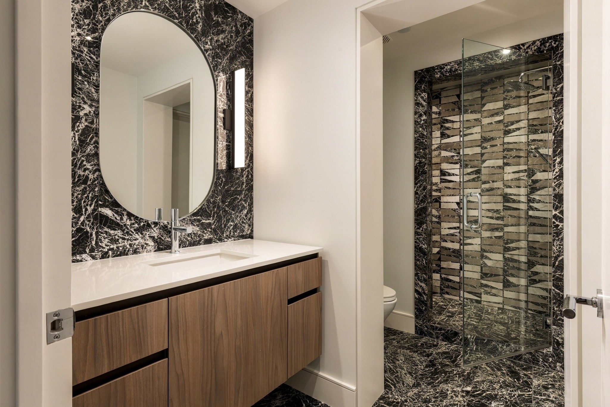 Gorgeous full bath off of media room with walk-in shower and floating vanity.
