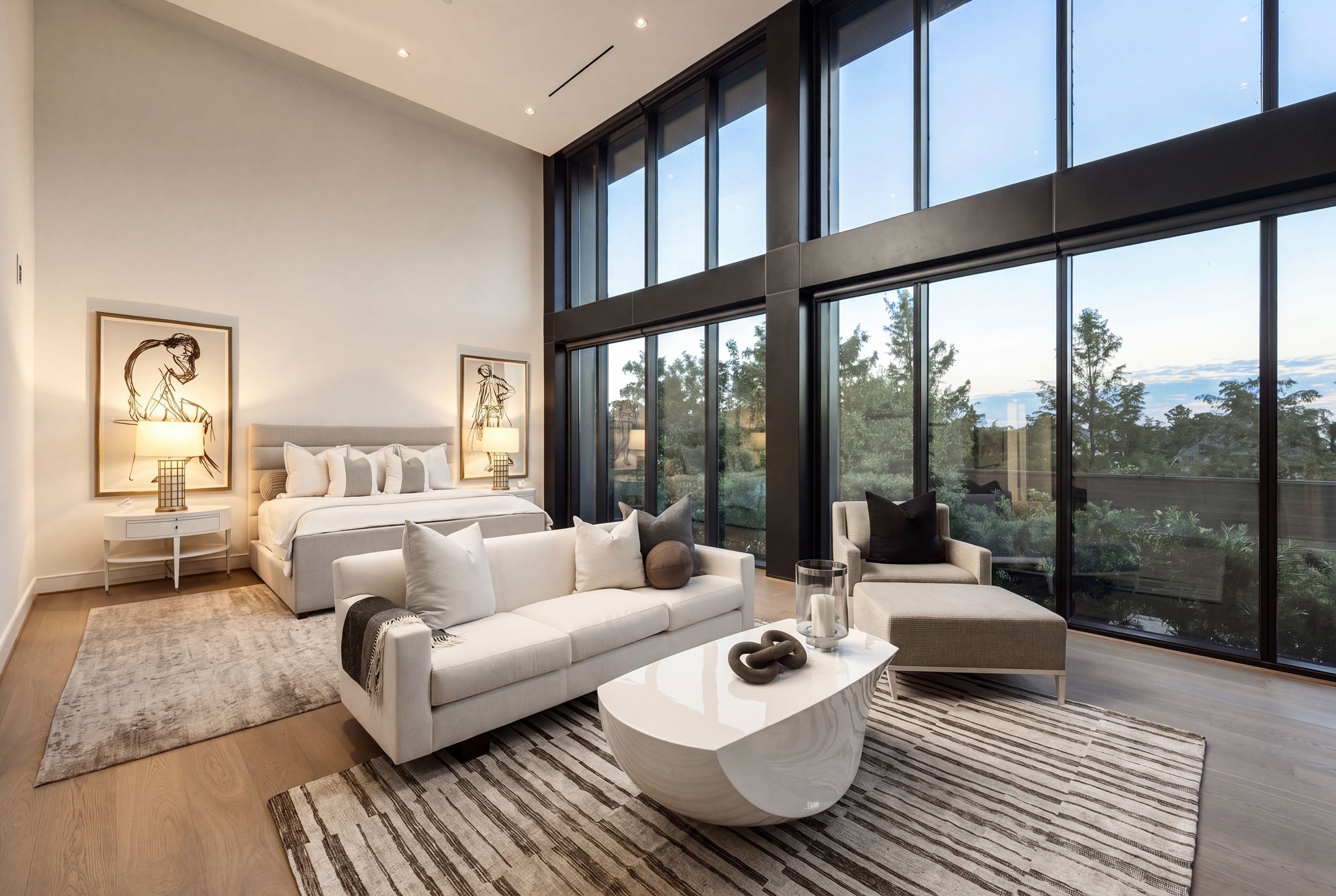 Sprawling main-floor primary suite features soaring 17+ foot ceilings and access to the private terrace.