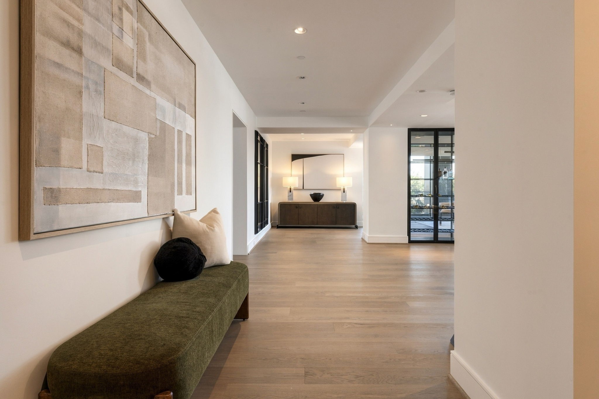 A gracious foyer introduces Listone Giordano Italian flooring, wide walls, tall ceilings, and recessed lighting.