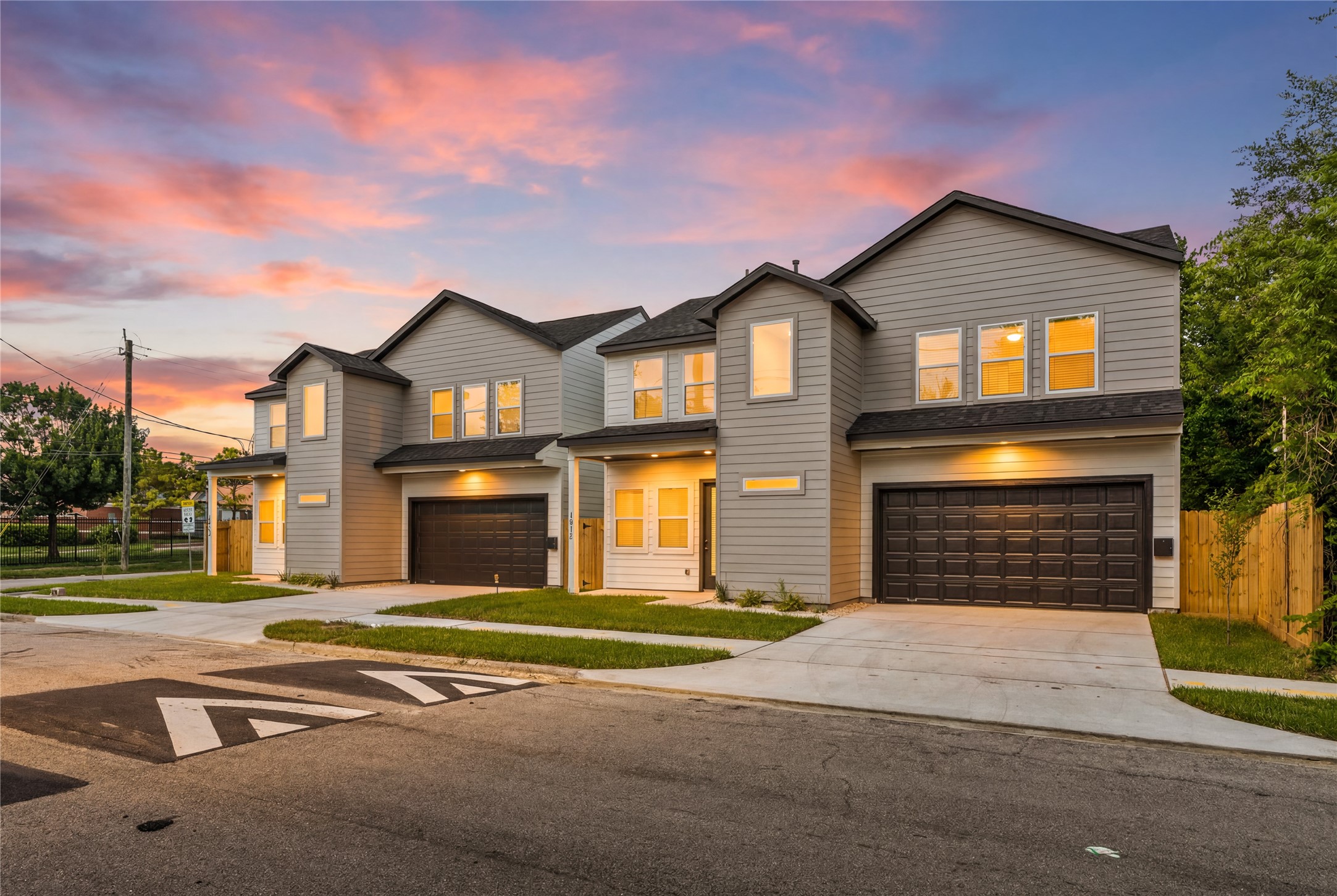 Golden hour elegance. The exterior lighting accents the modern geometry and rich textures of the home, showcasing a stunning street-side view that feels both secure and inviting.