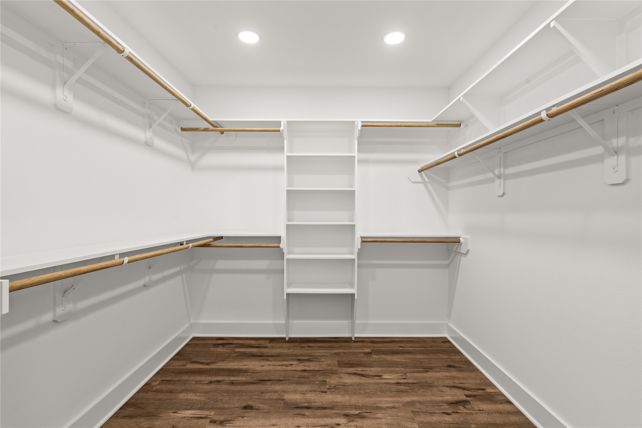 A wardrobe enthusiast's dream. The primary walk-in closet comes fully equipped with wrap-around custom built-ins, open shelving, and multi-level hanging rods.