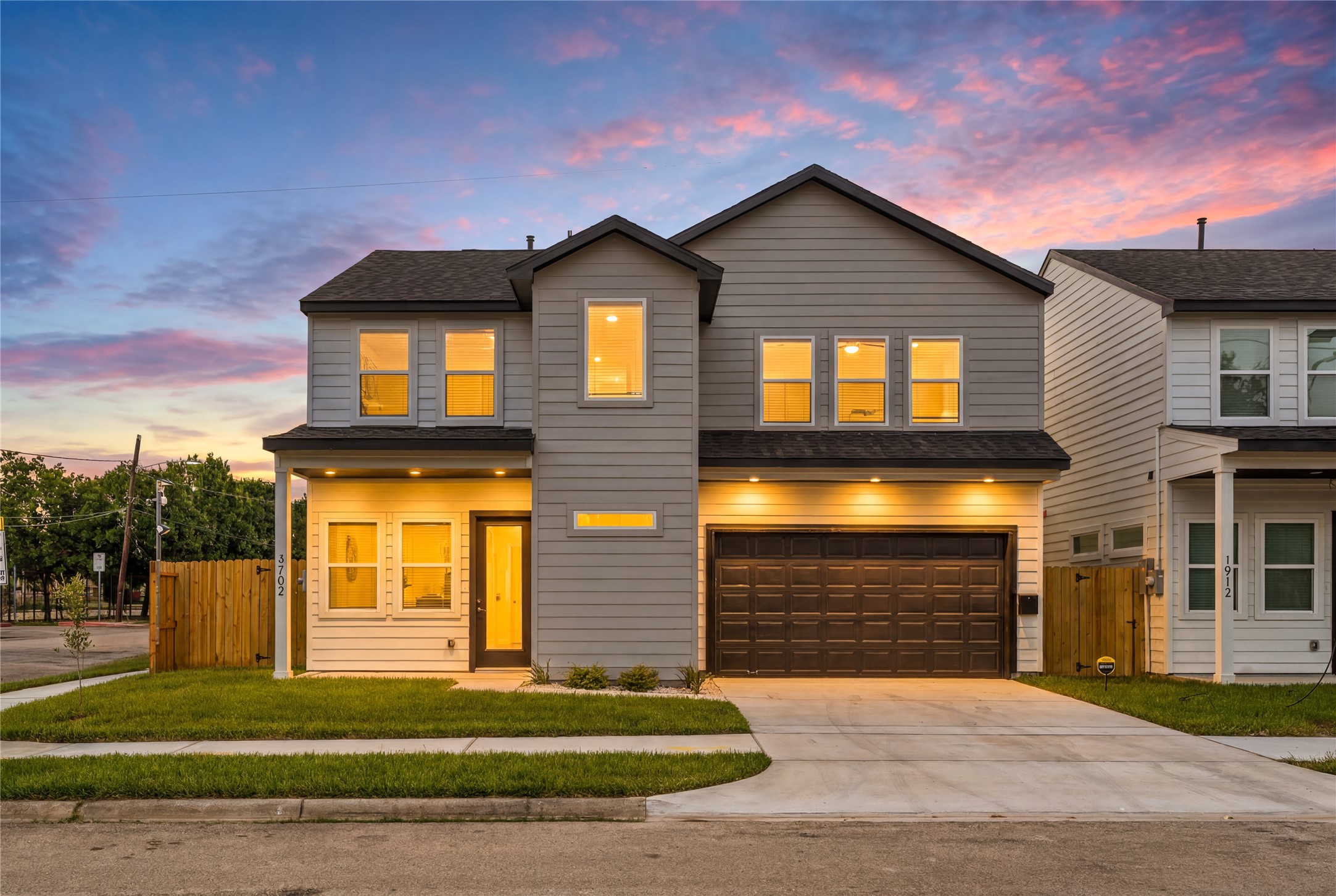 Stunning evening curb appeal  dramatic exterior uplighting beautifully showcases the sharp architectural lines against a vibrant Texas sunset.