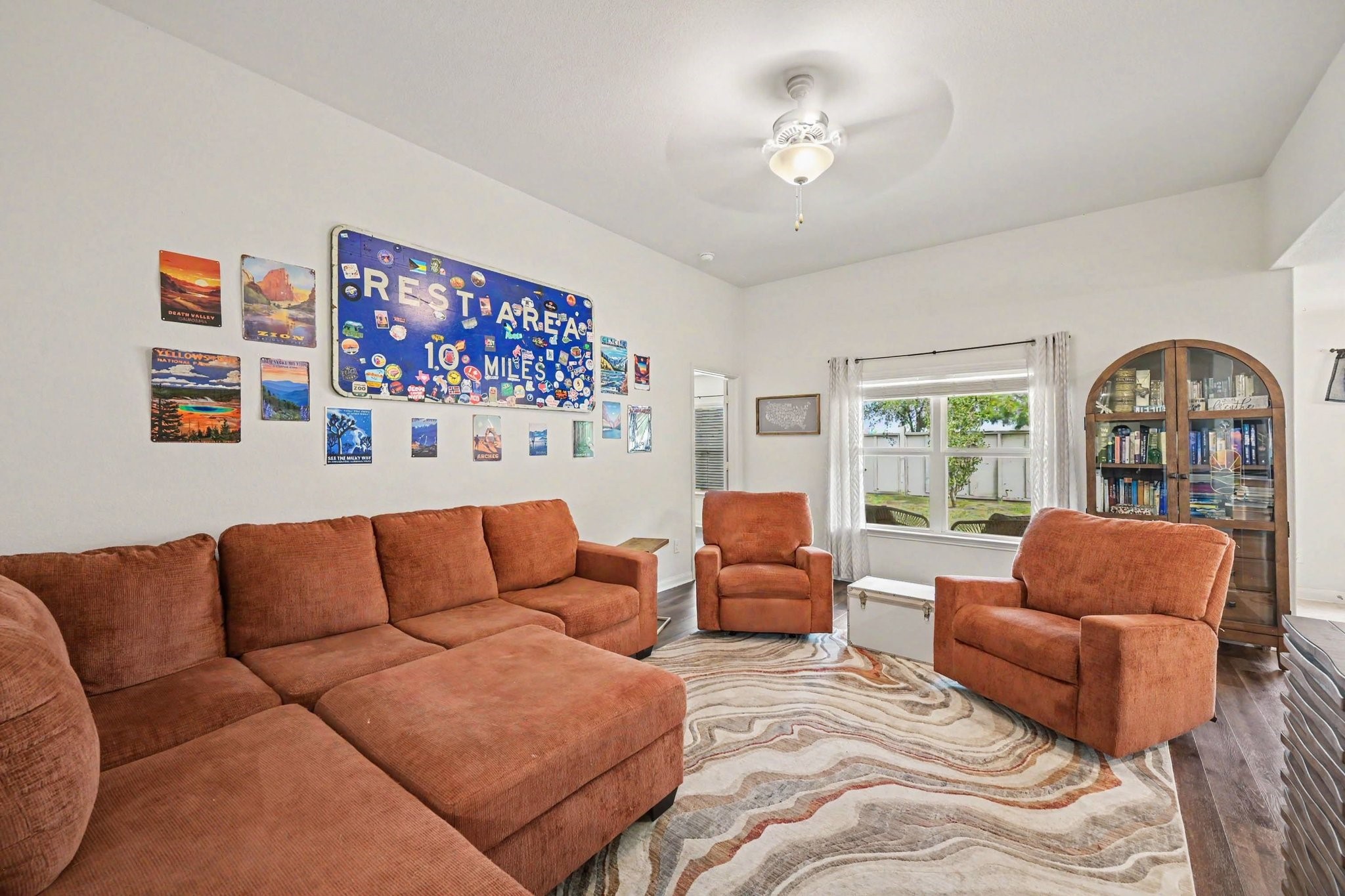 Open-concept family room featuring warm plank laminate flooring and ceiling fan