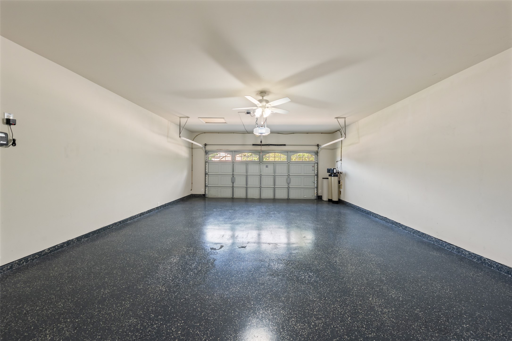 The attached garage has an epoxy floor, houses the sprinkler system controls, and the water softener system.