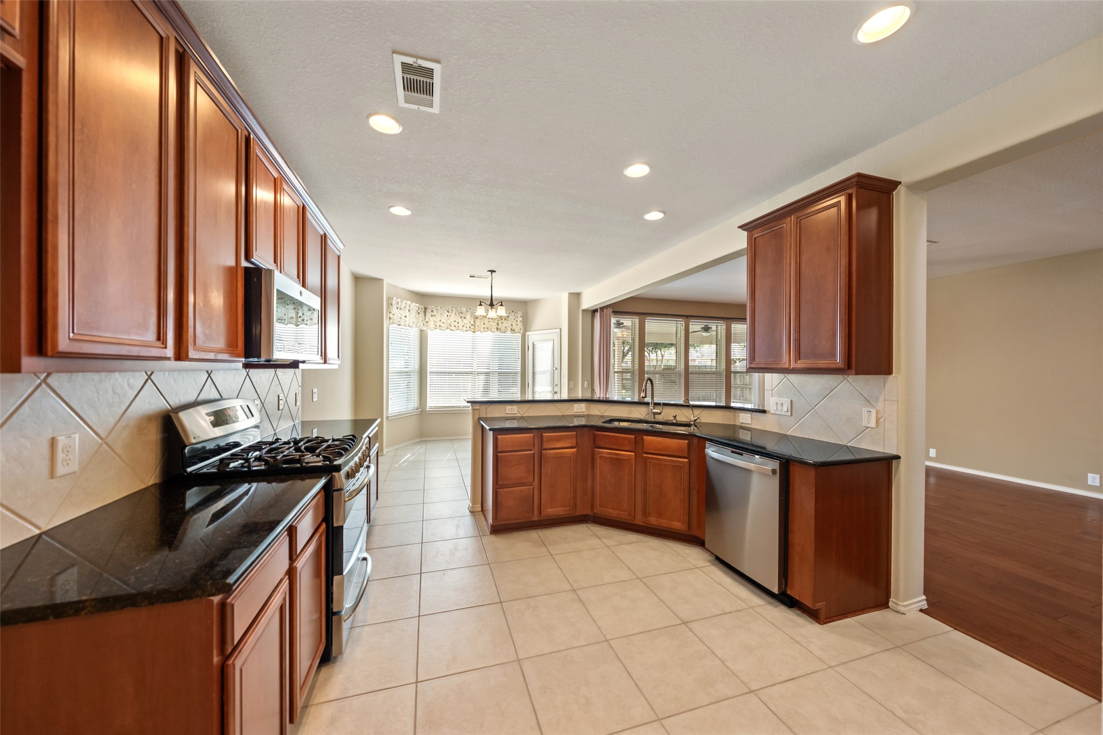 The kitchen features granite counters, SS appliances, and loads of cabinet space.