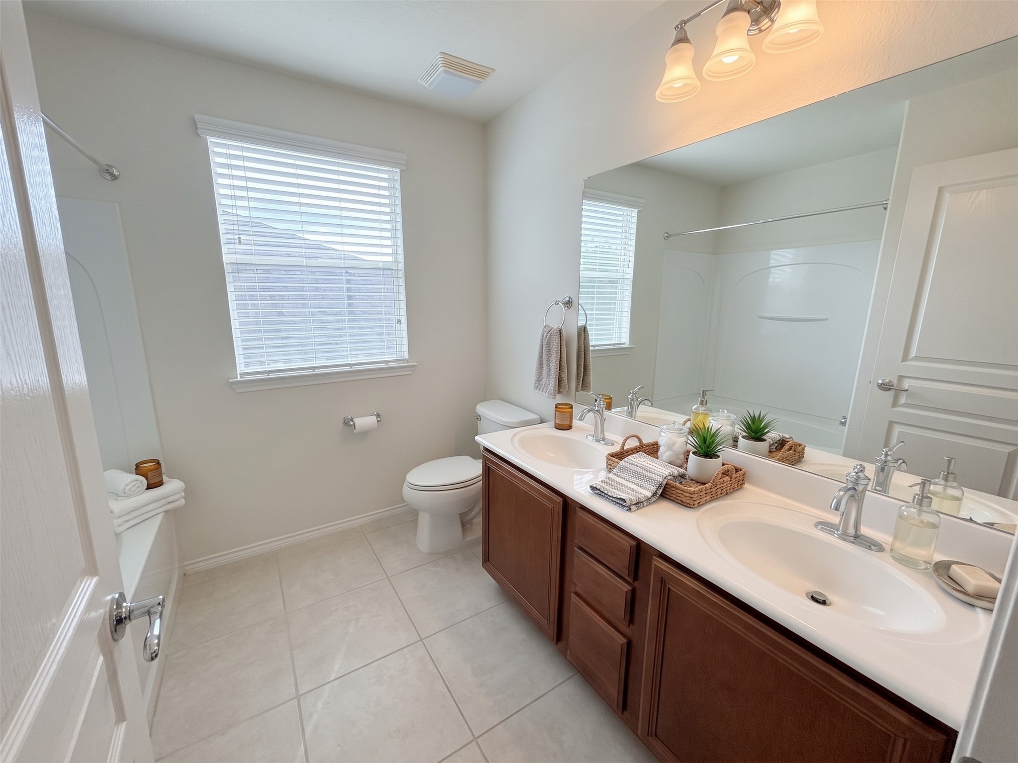 The upstairs full bath has dual sinks and a tub shower.  Virtually staged photo.  Also freshly painted.