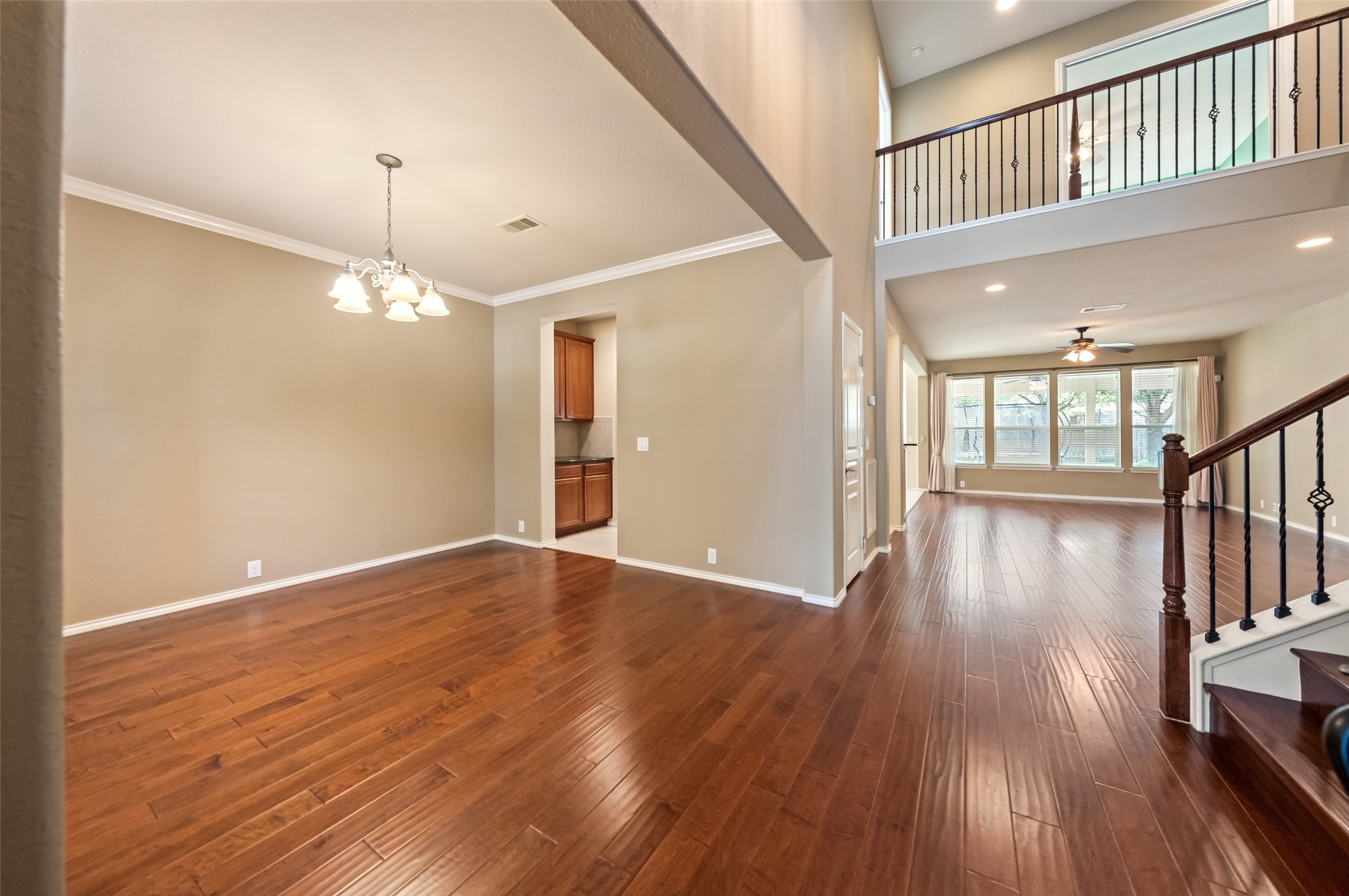Gleaming wood flooring spans across the entry, dining room, living room, and 5th bedroom/home office.