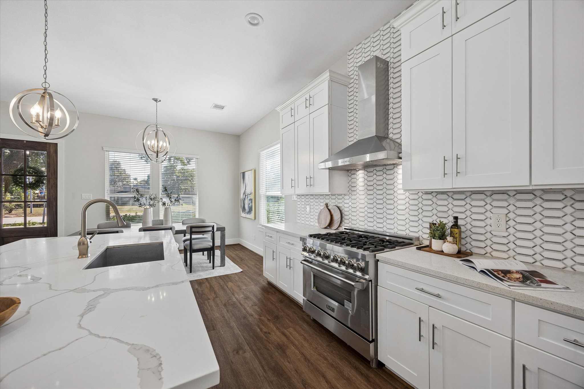 Cooking is a pleasure when everything is right where you need it! A gas range with statement stainless steel vent hood, convenient island microwave and dishwasher make meal prep and cleanup a breeze. Quartz countertops provide plenty of workspace, while designer tile adds a stylish finishing touch.