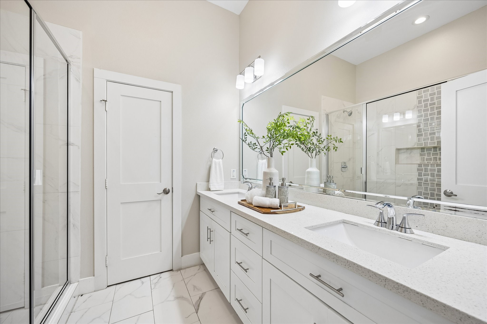 Guests will enjoy a little privacy and a lot of pampering in this beautifully finished ensuite. A long vanity with dual sinks, ample counter space and plenty of storage makes busy mornings easier, while a spacious glass-enclosed shower offers a refreshing start to the day.