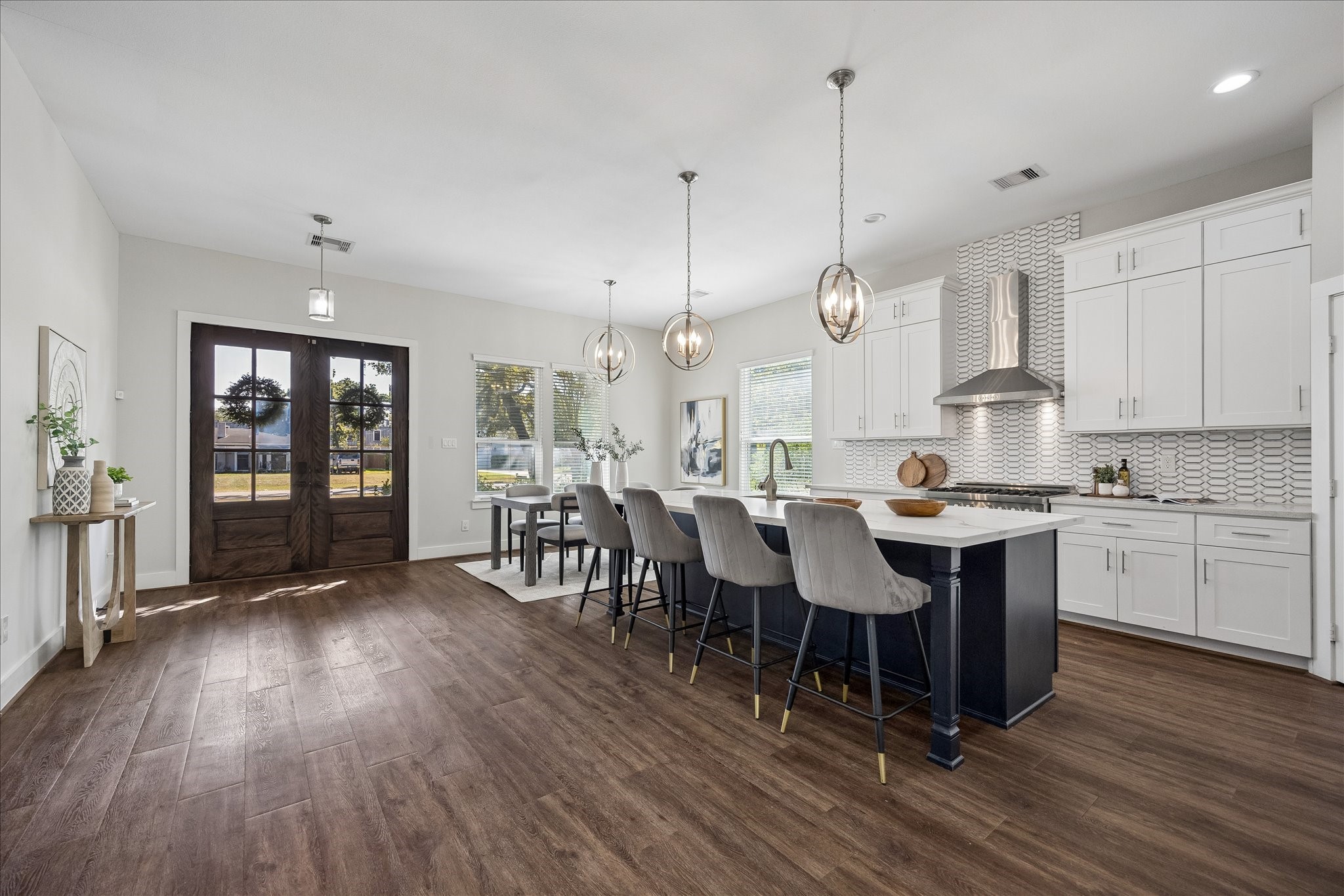 From quick weekday breakfasts to big holiday gatherings, this kitchen is ready for it all! Crisp white cabinetry, a spacious contrasting island with bar seating, stylish pendant lights, stainless steel appliances and sleek tile backsplash bringing plenty of style and charm right into the heart of the home.