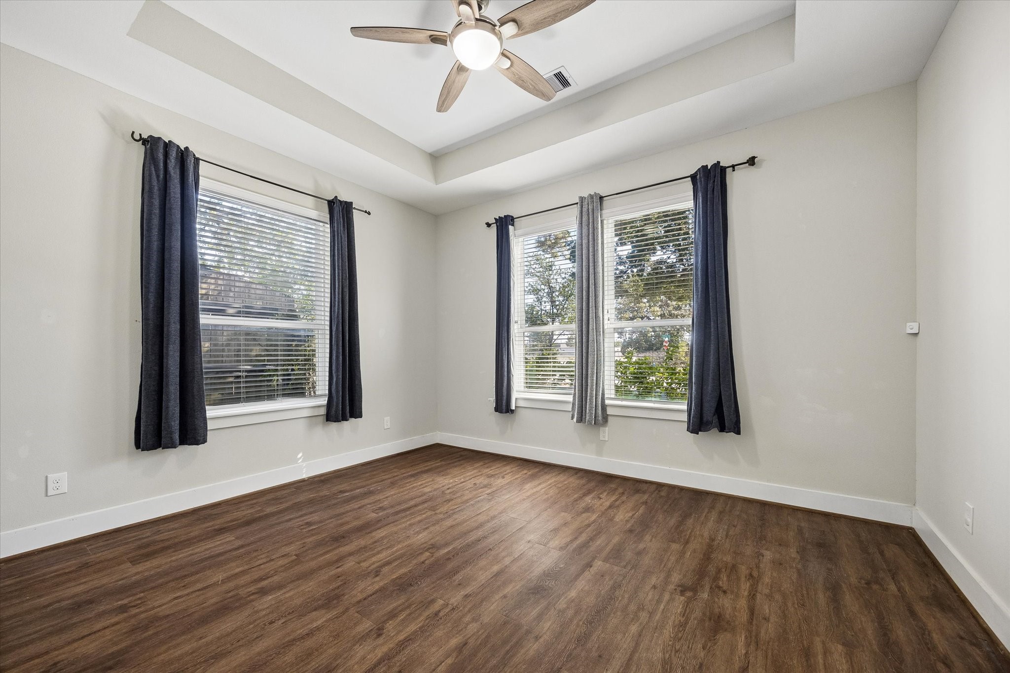 Your guests will feel right at home in this bright, inviting bedroom with a beautiful tray ceiling, cooling ceiling fan and updated luxury vinyl tile flooring. Large windows welcome plenty of natural light, while a spacious closet and nearby full bathroom make it easy to unpack and stay awhile.